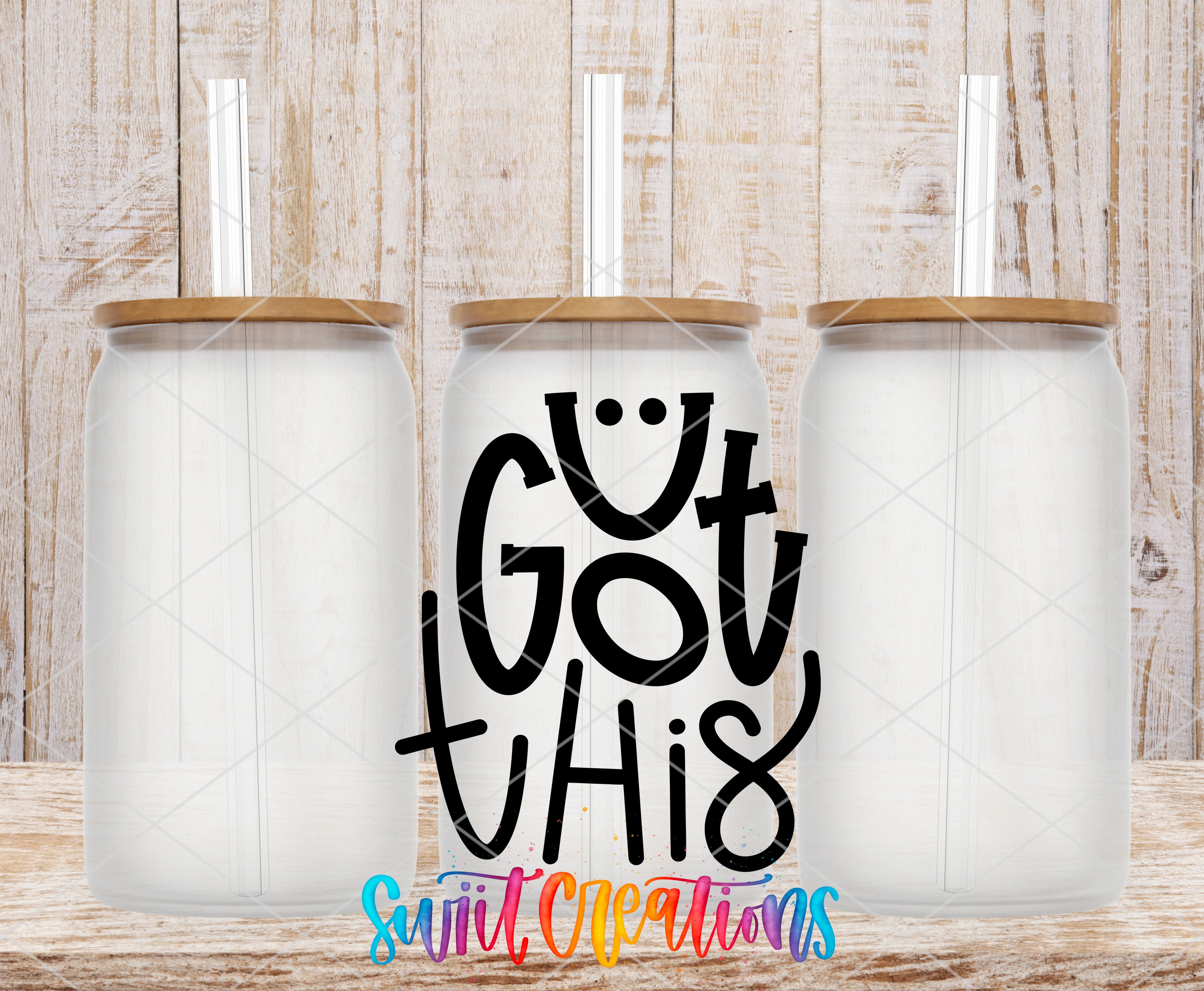 three transparent glass jars with wooden lids, arranged in a row against a wooden background. The jars have straws attached to their lids. The phrase "GOT THIS" is written in a stylized font in the center of the image.