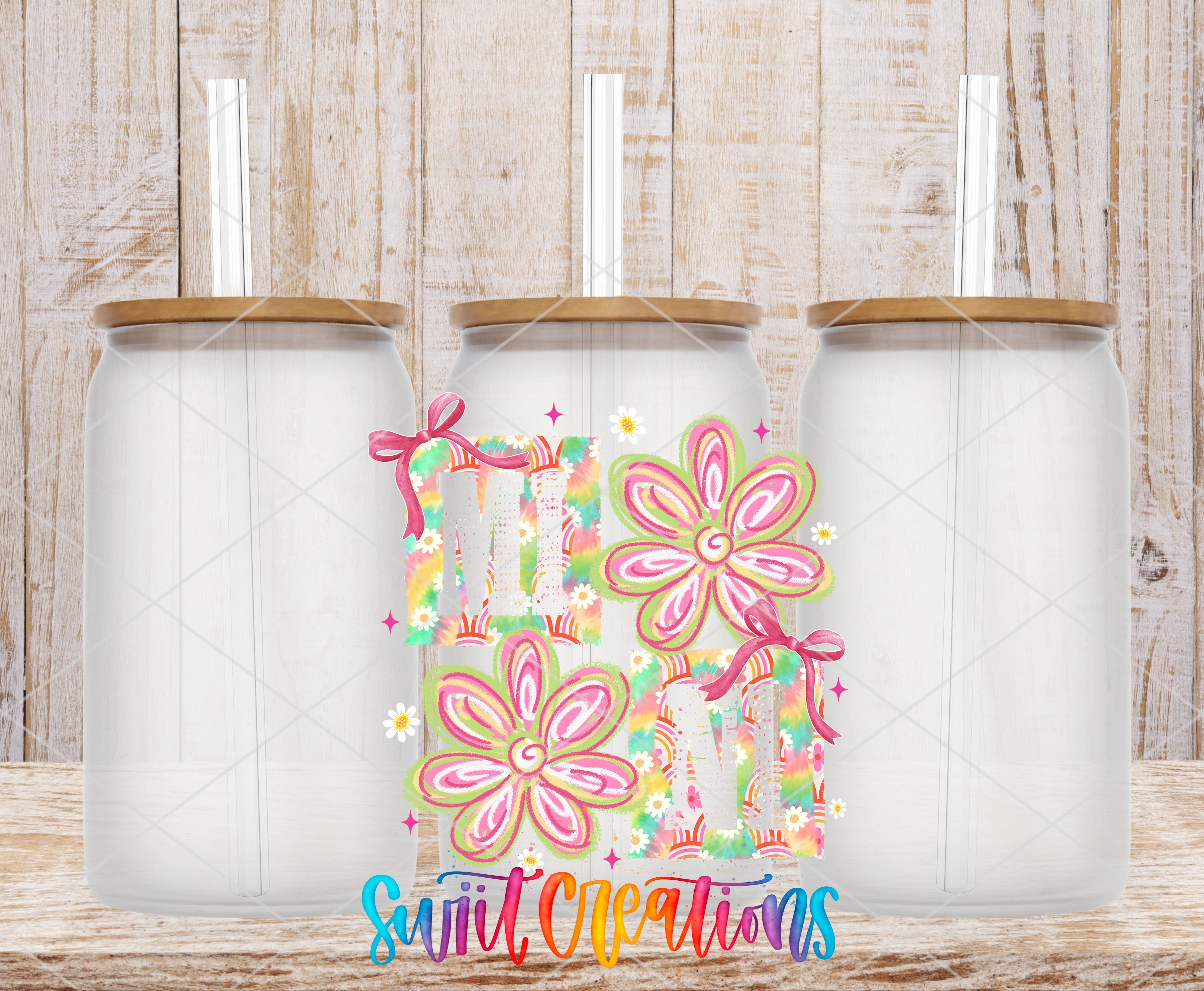 three glass jars with lids, each with a straw, arranged in a row against a wooden background.