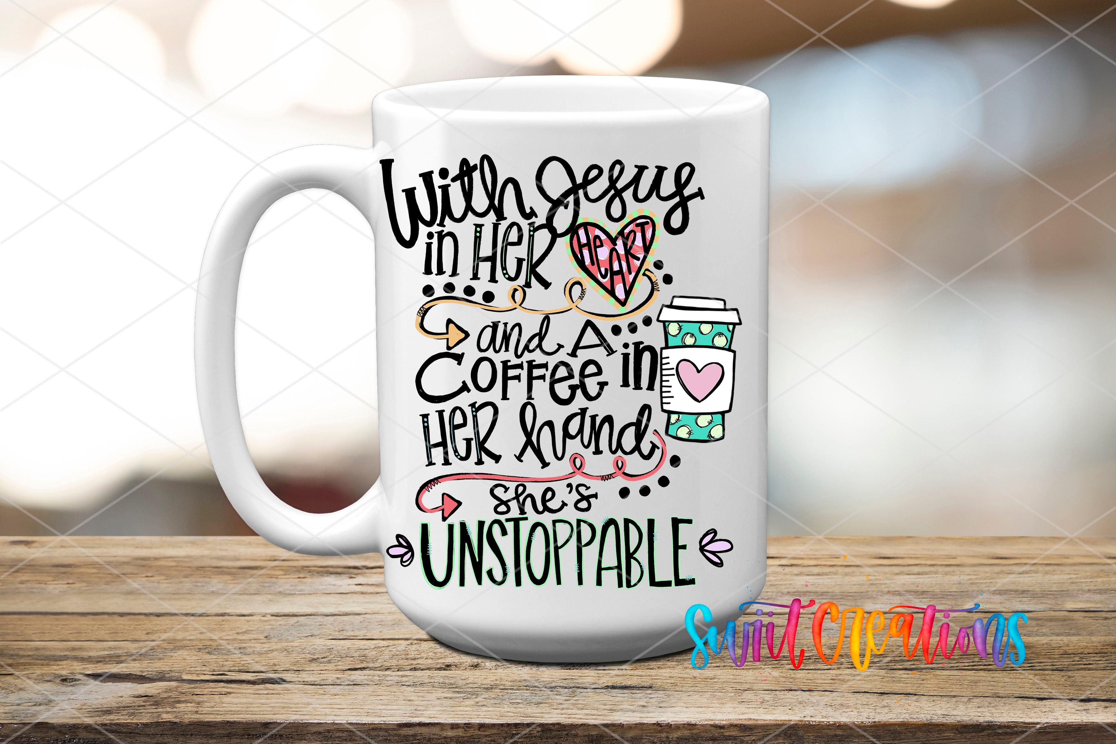 A white coffee mug with colorful text and illustrations on it, placed on a wooden surface.