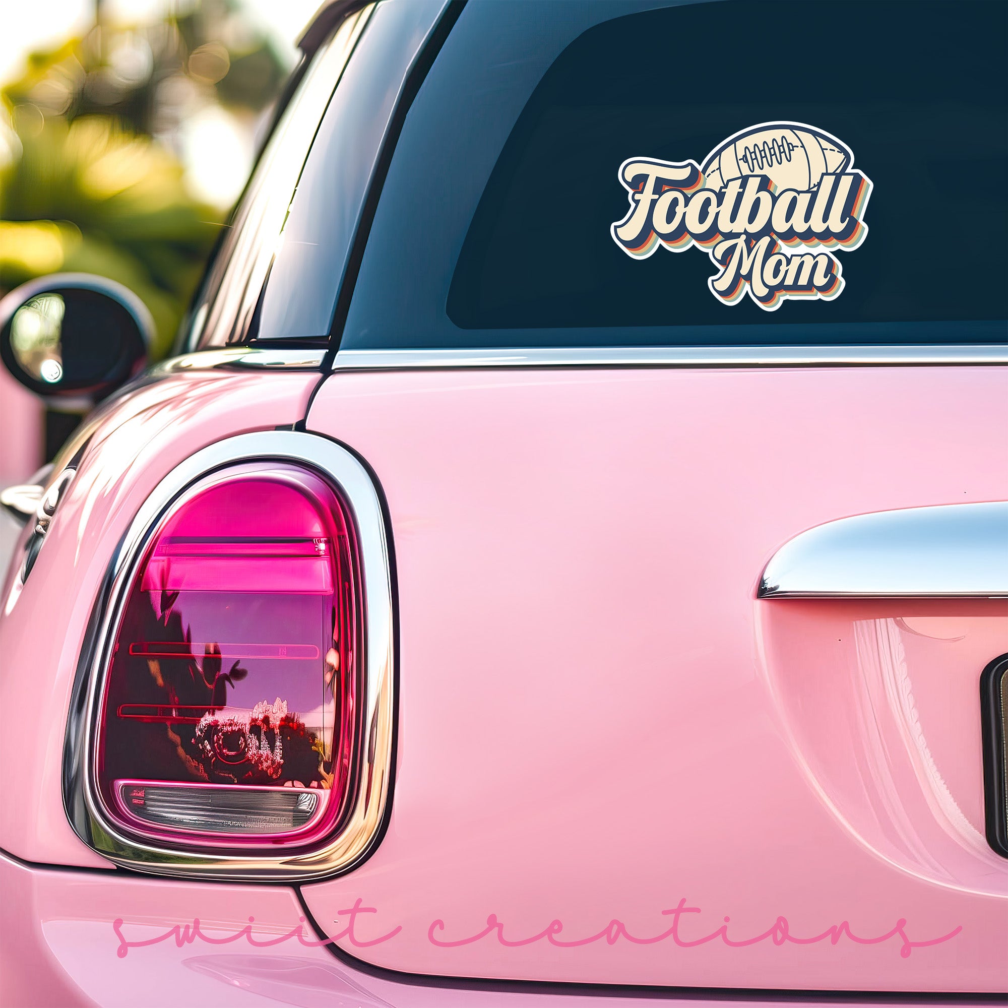 a pink car with a football mom decal on it