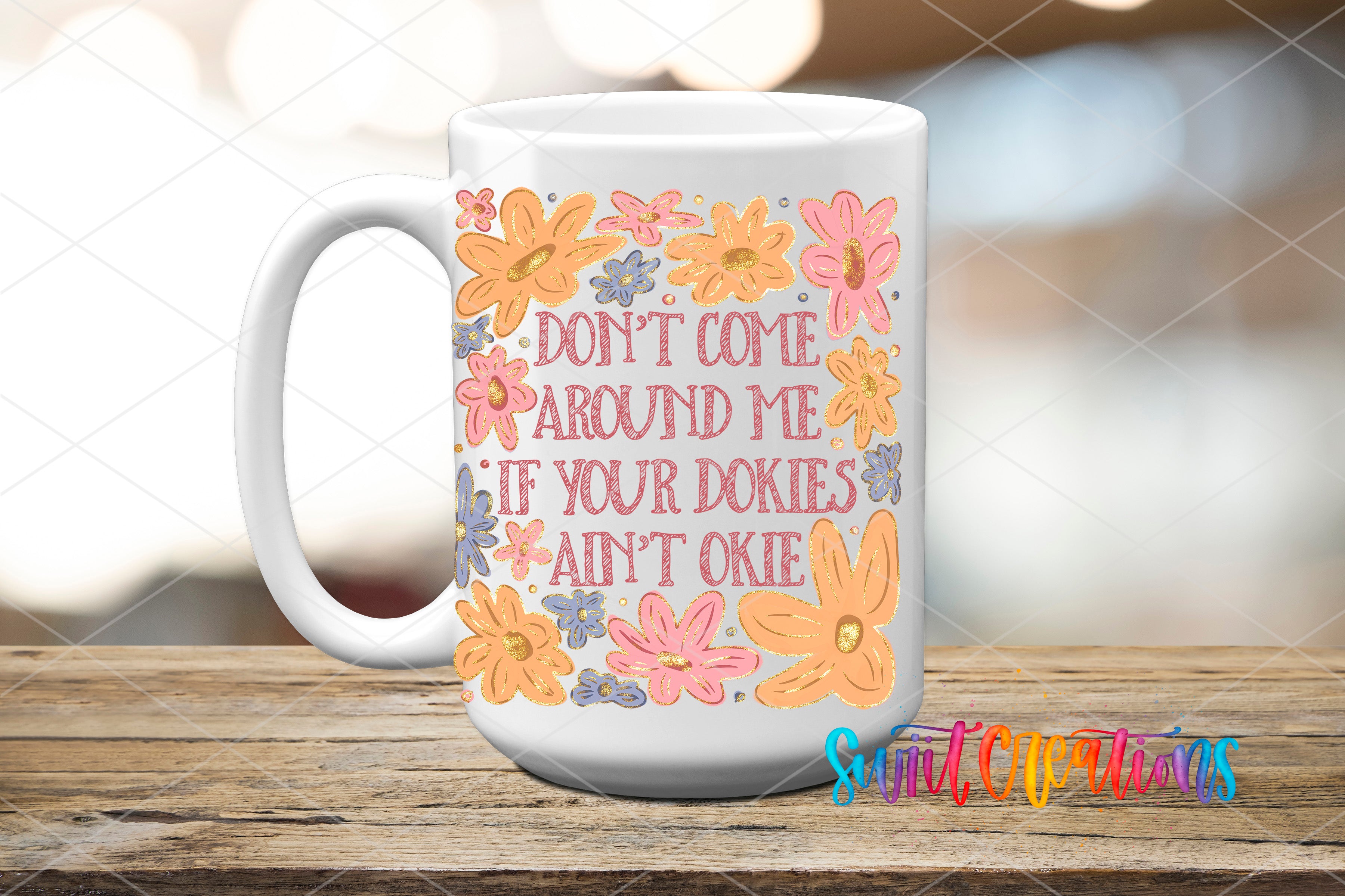 A white mug with a colorful floral design and text printed on it, placed on a wooden surface.