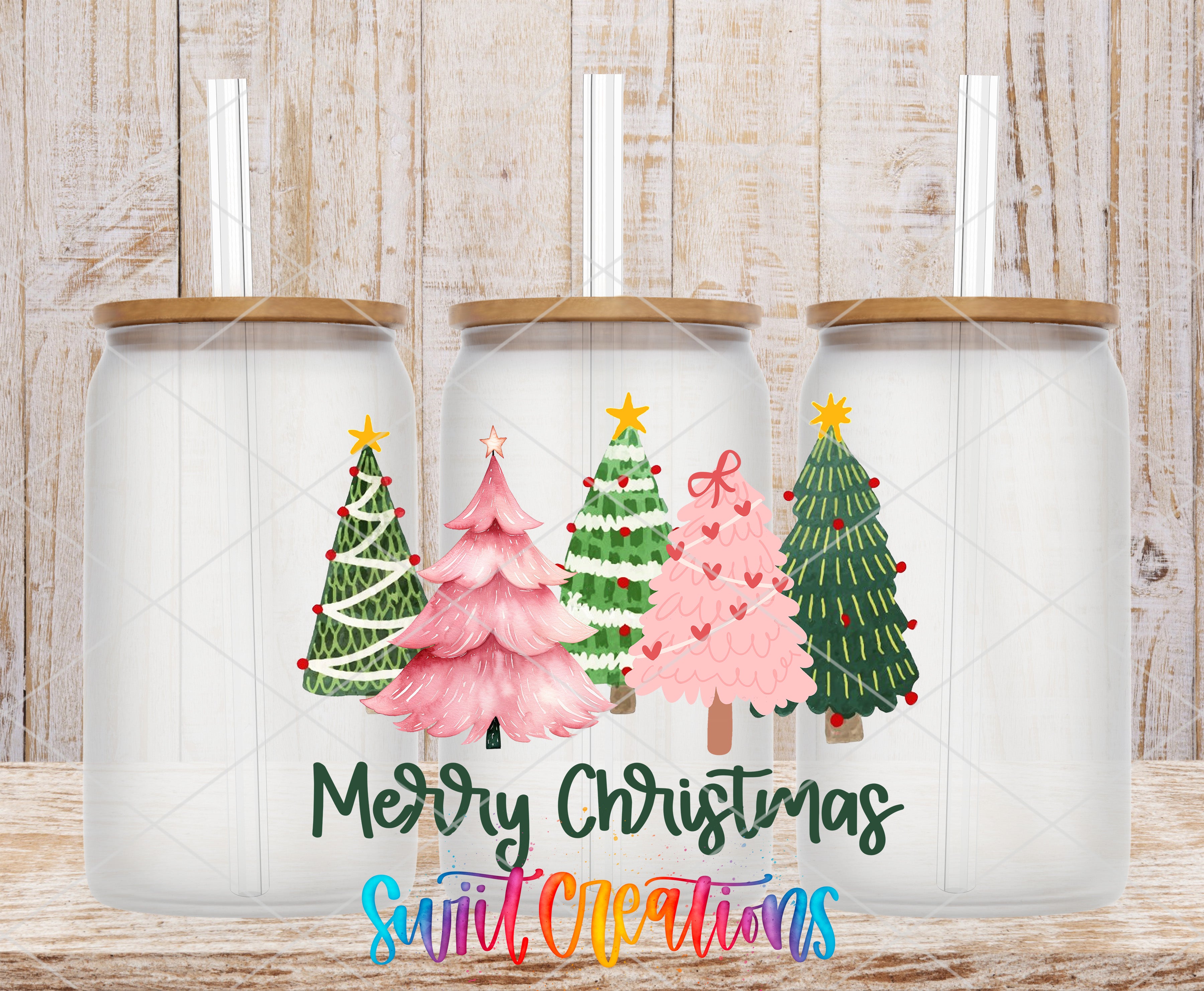 three glass jars with Christmas tree designs on them, set against a wooden background.