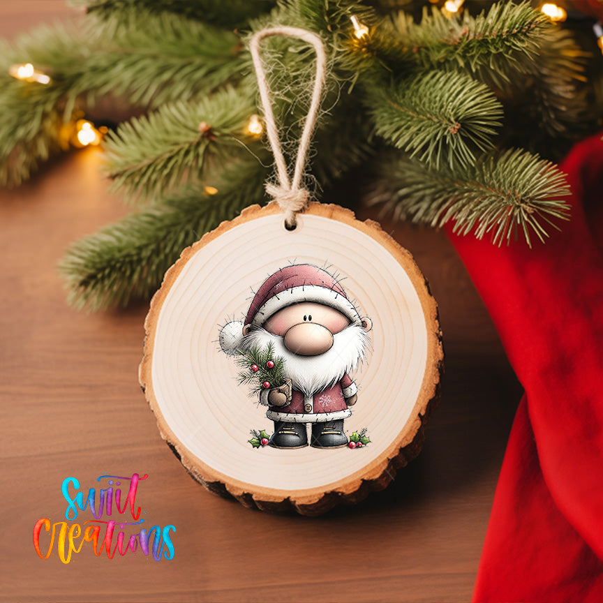 A wooden ornament featuring a cartoon Santa Claus figure is hanging on a Christmas tree, surrounded by pine branches and twinkling lights.
