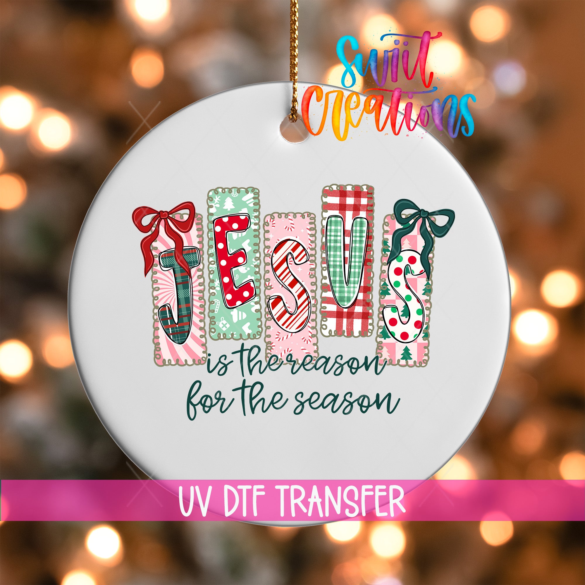 A white ornament with the word "JESUS" spelled out in colorful letters, hanging against a background of Christmas lights.