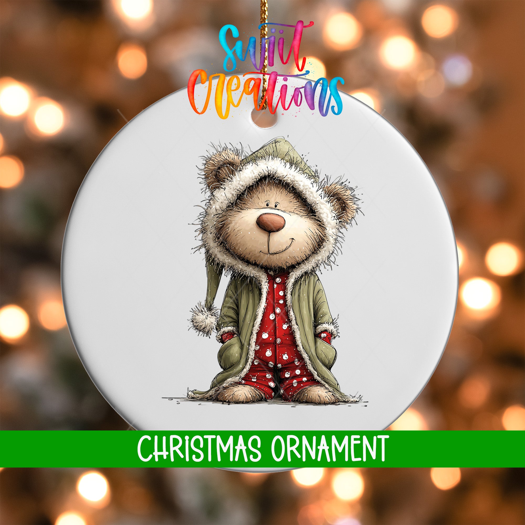 A white Christmas ornament featuring a cartoon bear wearing a green coat and red polka dot pants, with a smiling expression.