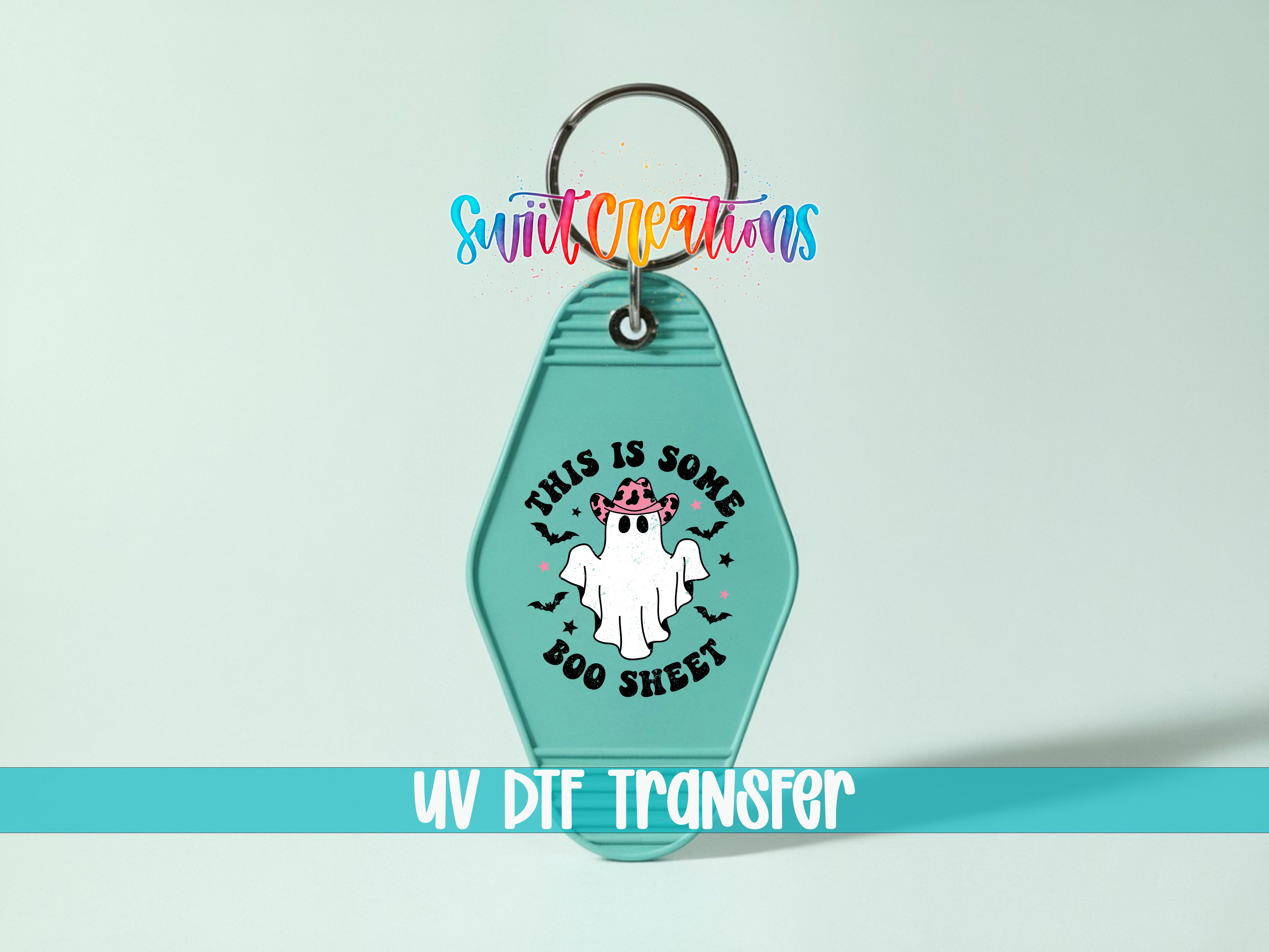 A keychain with a ghost design and text, along with a UV DIF transfer label.