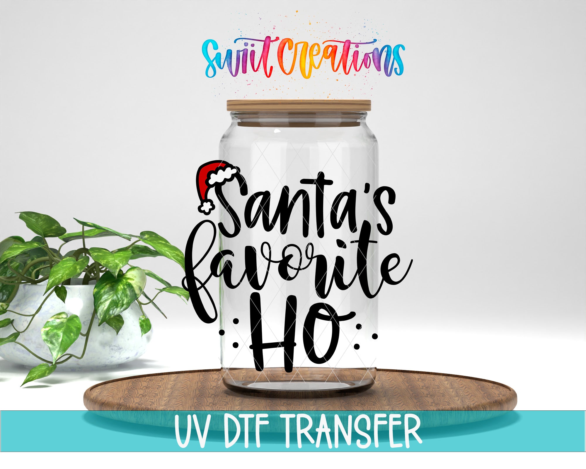 A clear glass jar with a wooden lid, featuring a Santa Claus hat and the text "Santa's favorite ho" in a stylized font. The jar is placed on a wooden surface, and there is a potted plant in the background.
