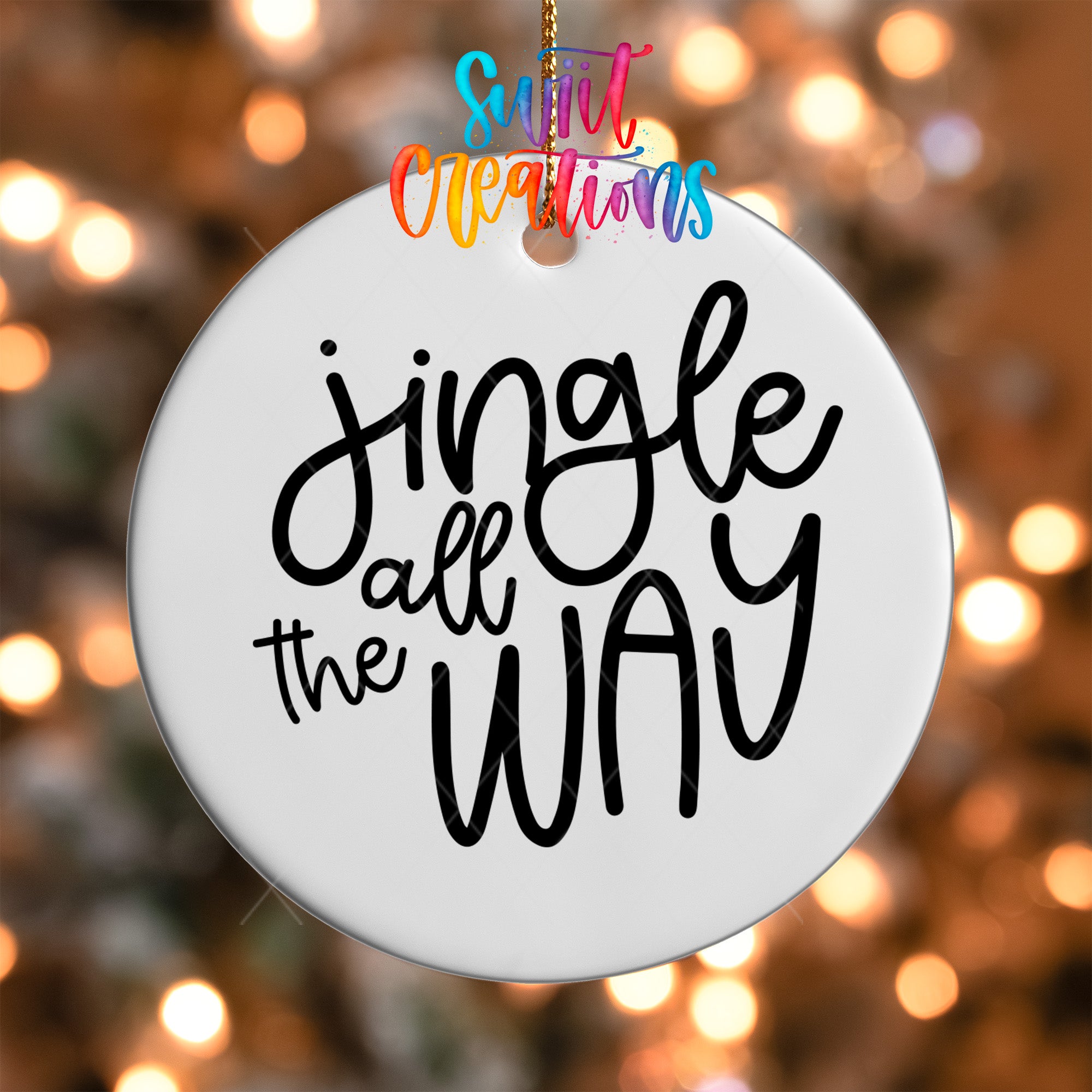 A white ornament with the text "Jingle all the way" written on it, hanging against a background of colorful lights.