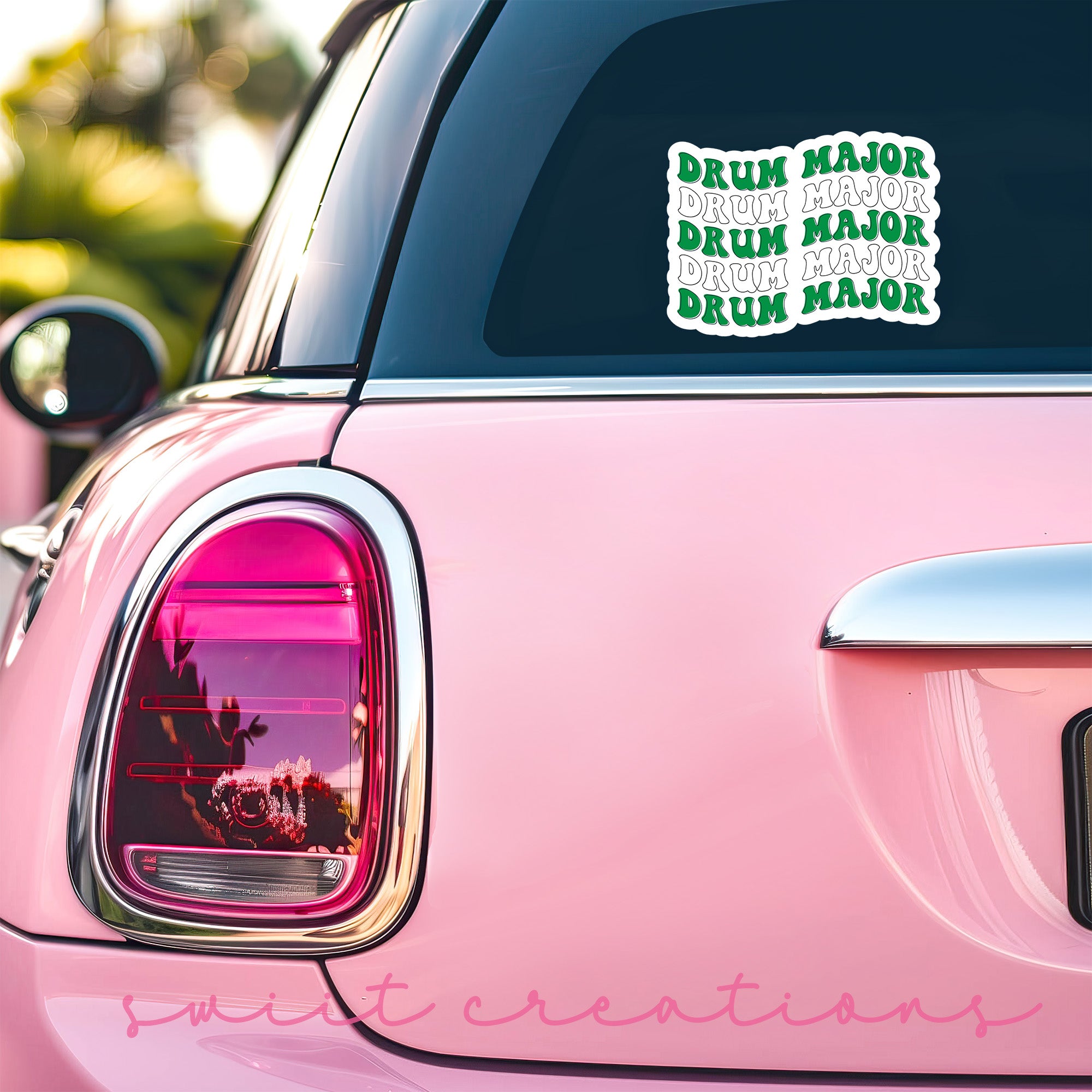 a pink car with a green sticker on it