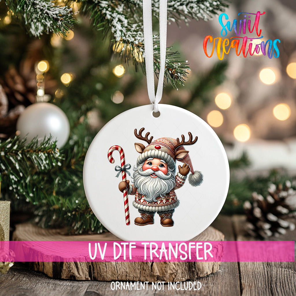 A white ornament with a Santa Claus figure and a candy cane hangs on a Christmas tree.