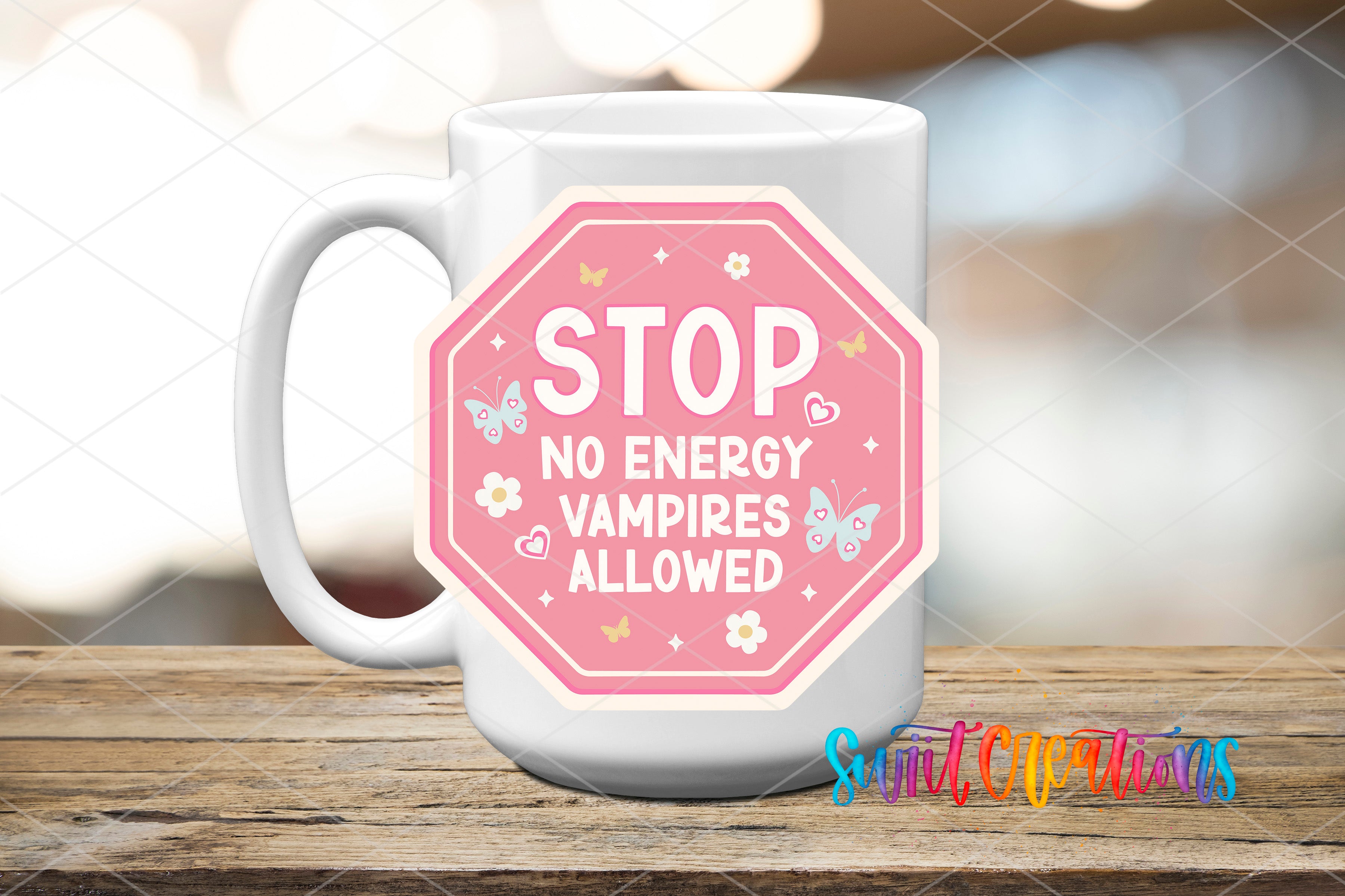 A white mug with a pink octagonal sticker on it, placed on a wooden surface.