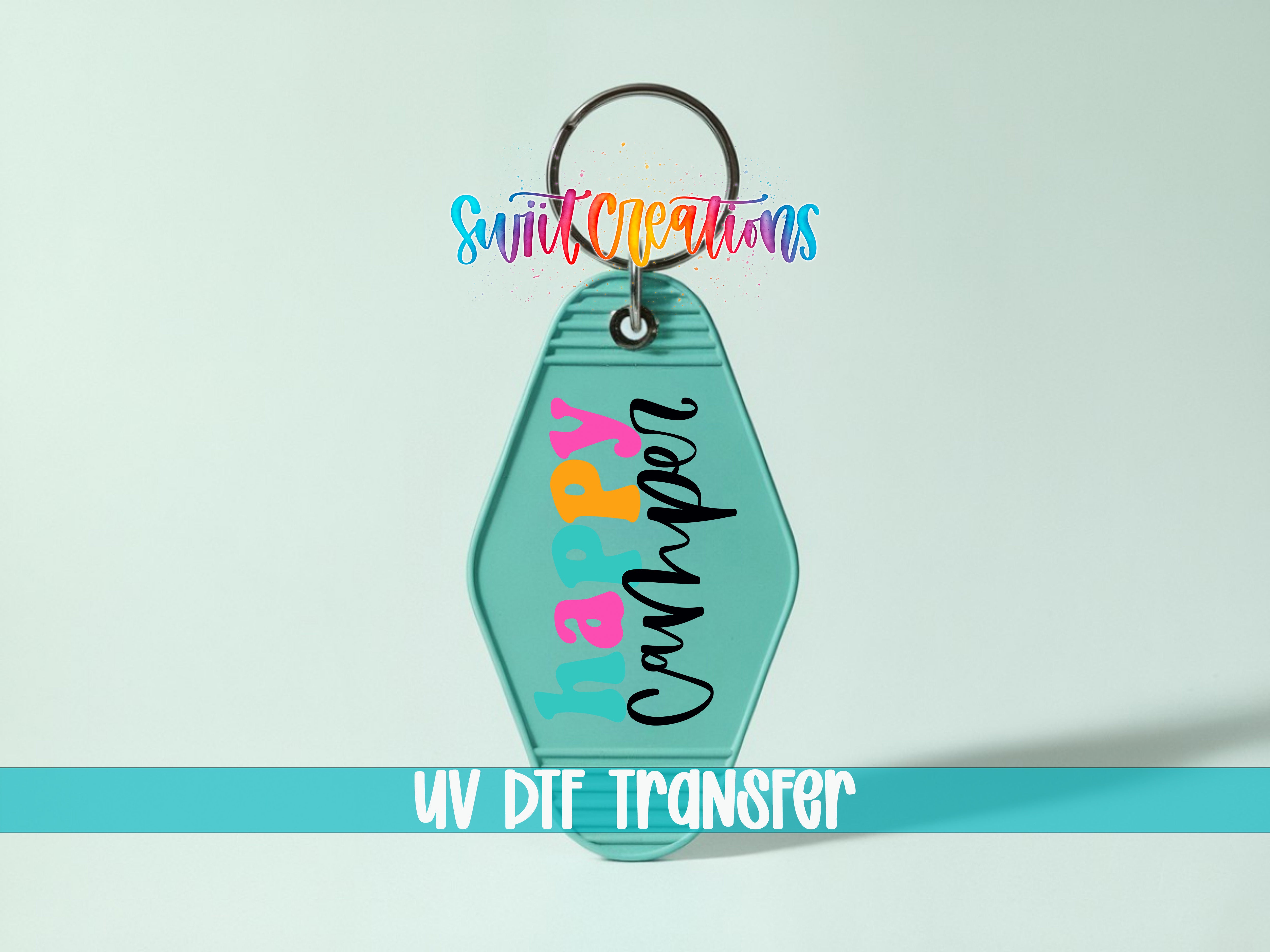A keychain with a colorful design and text, including the words "Happy Camper" and "UV DIF TRANSFER".