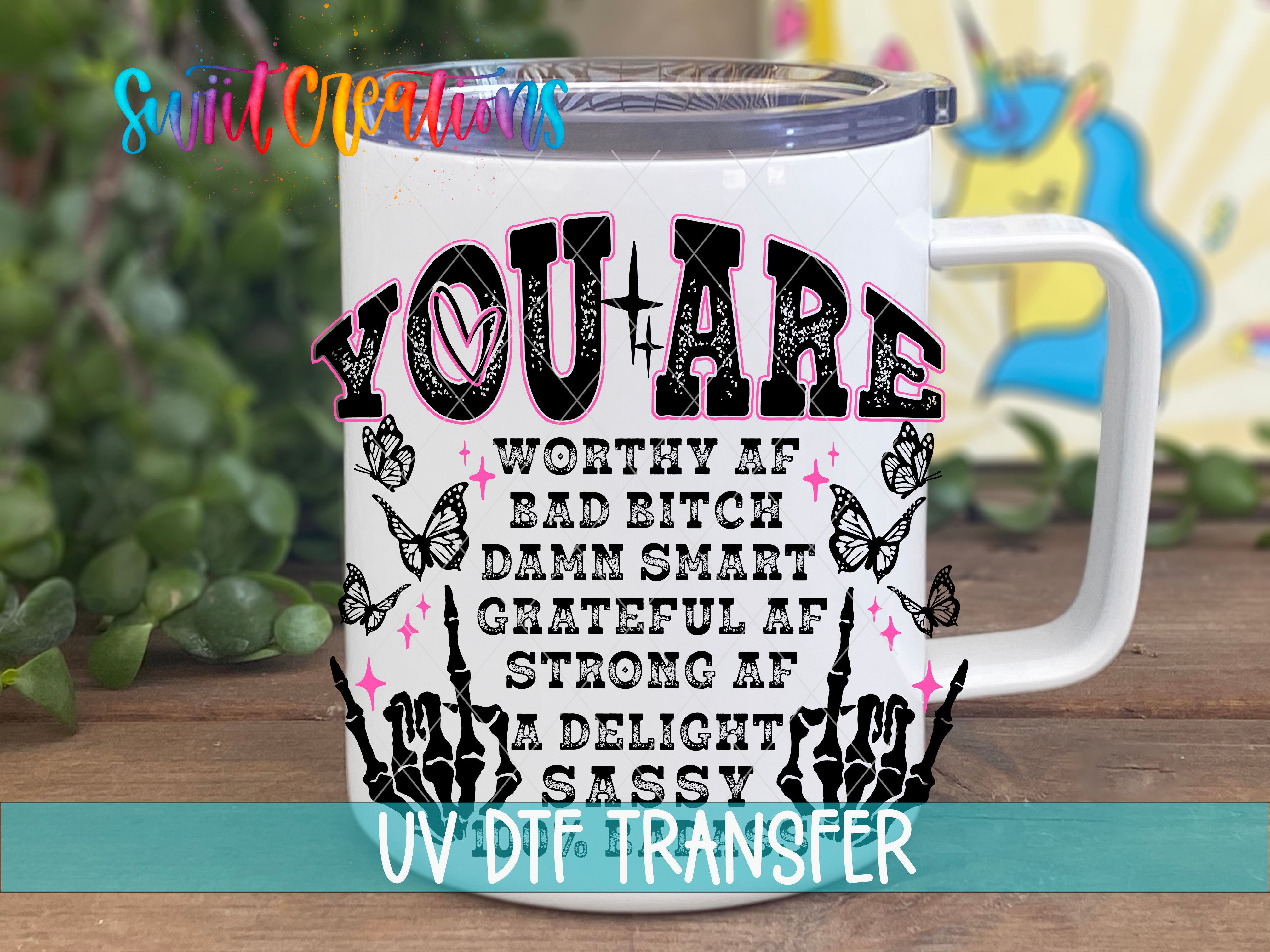 A white mug with a colorful and playful design featuring text and illustrations.