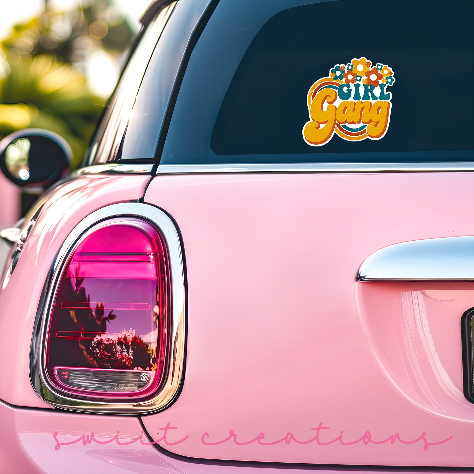 a pink car with a sticker on the back of it