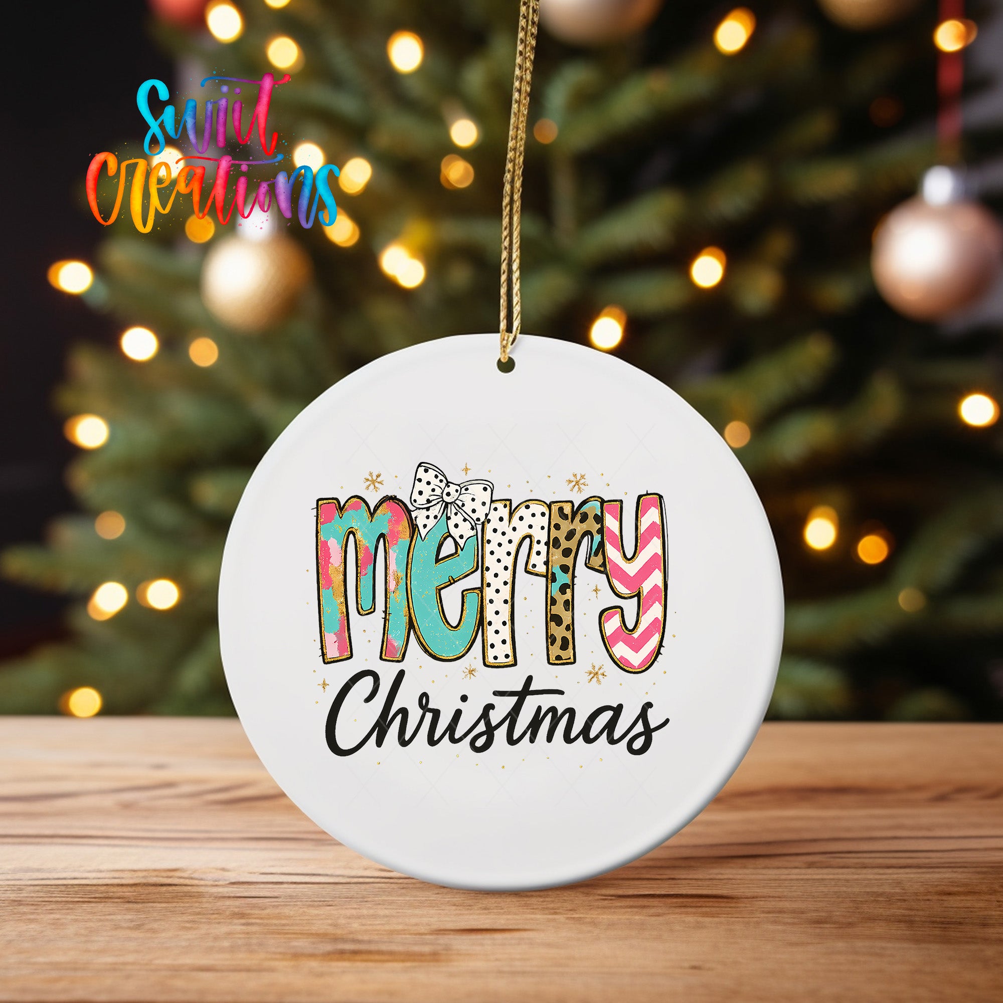 A white ceramic ornament with the text "MERRY CHRISTMAS" written on it, hanging from a string.