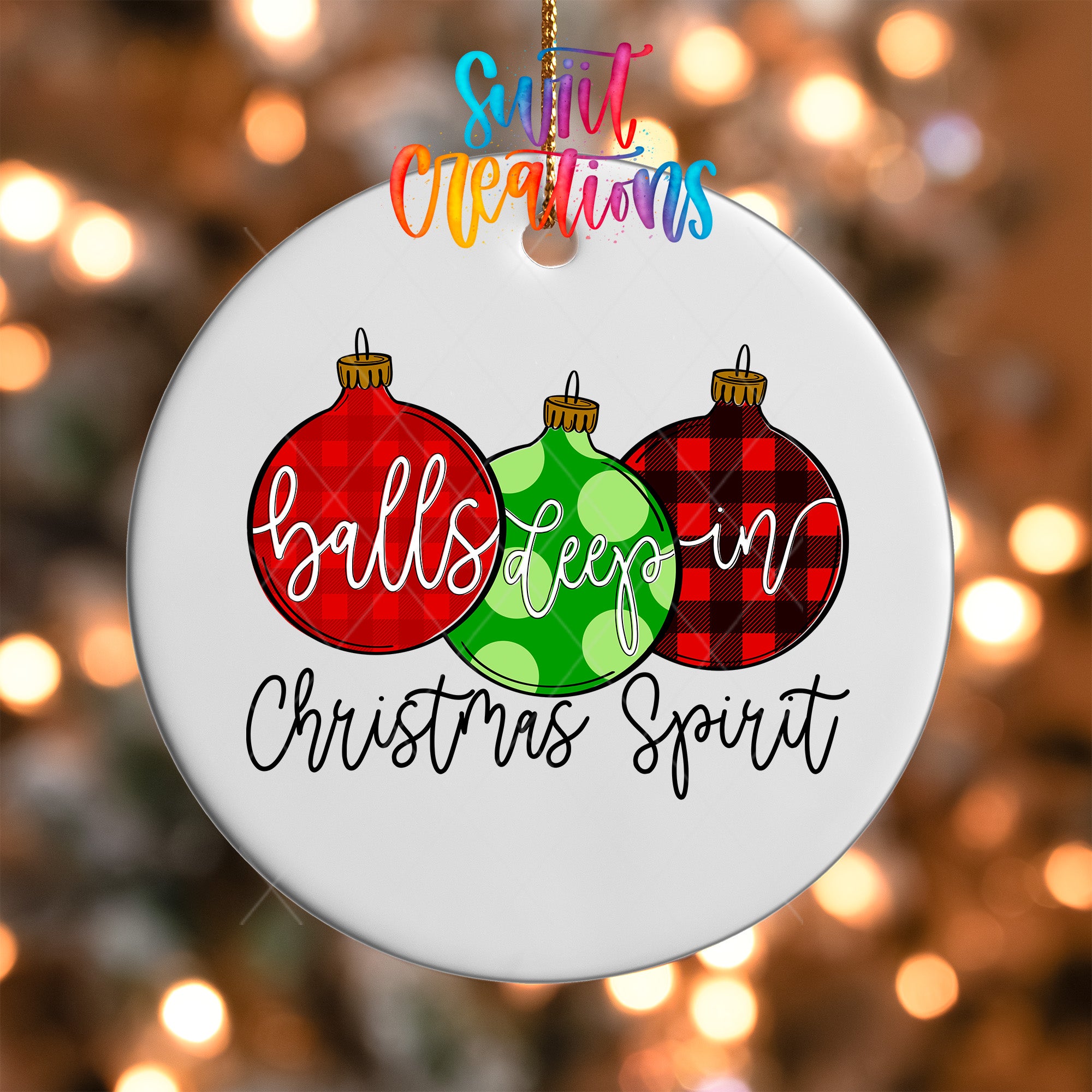 A white ornament with three Christmas ornaments hanging from a string, each with a different color and pattern. The ornament has the text "balls deep in Christmas spirit" written on it.