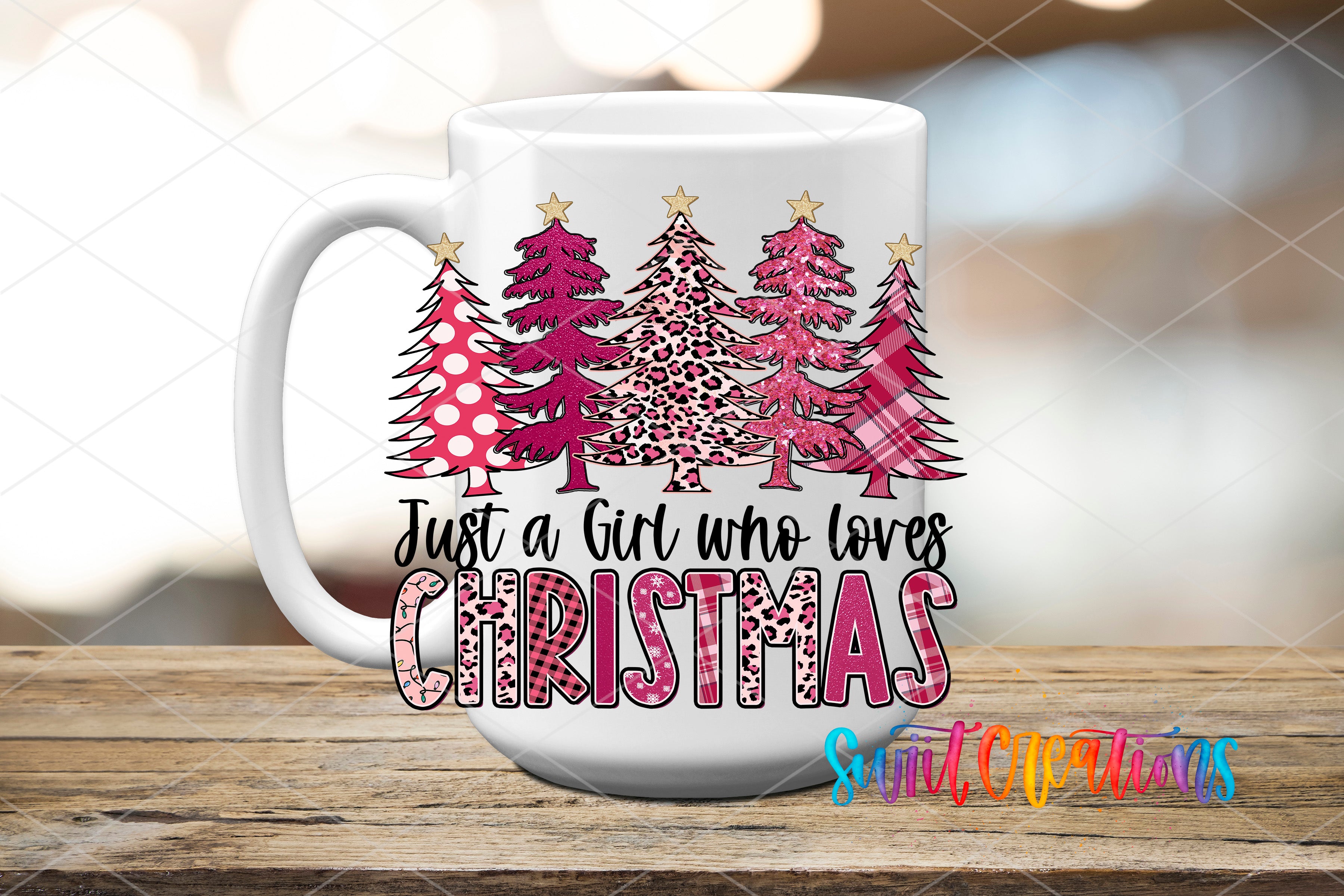 A white mug with a Christmas tree design and text on it, placed on a wooden surface.