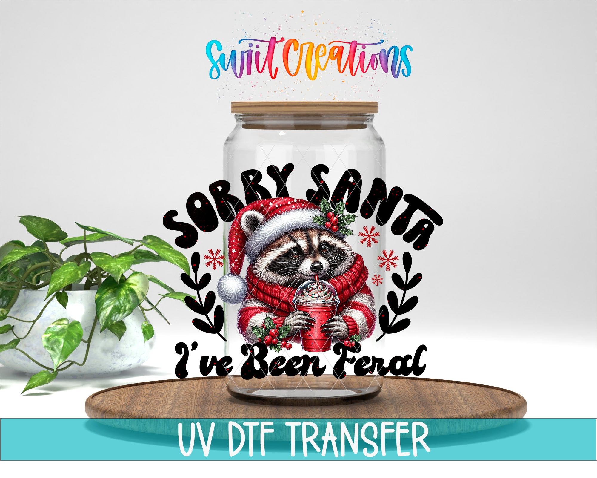 A jar with a raccoon wearing a Santa hat and holding a cup of hot chocolate, accompanied by the text "Sorry Santa I've Been Ferral" and the UV DFT Transfer logo.