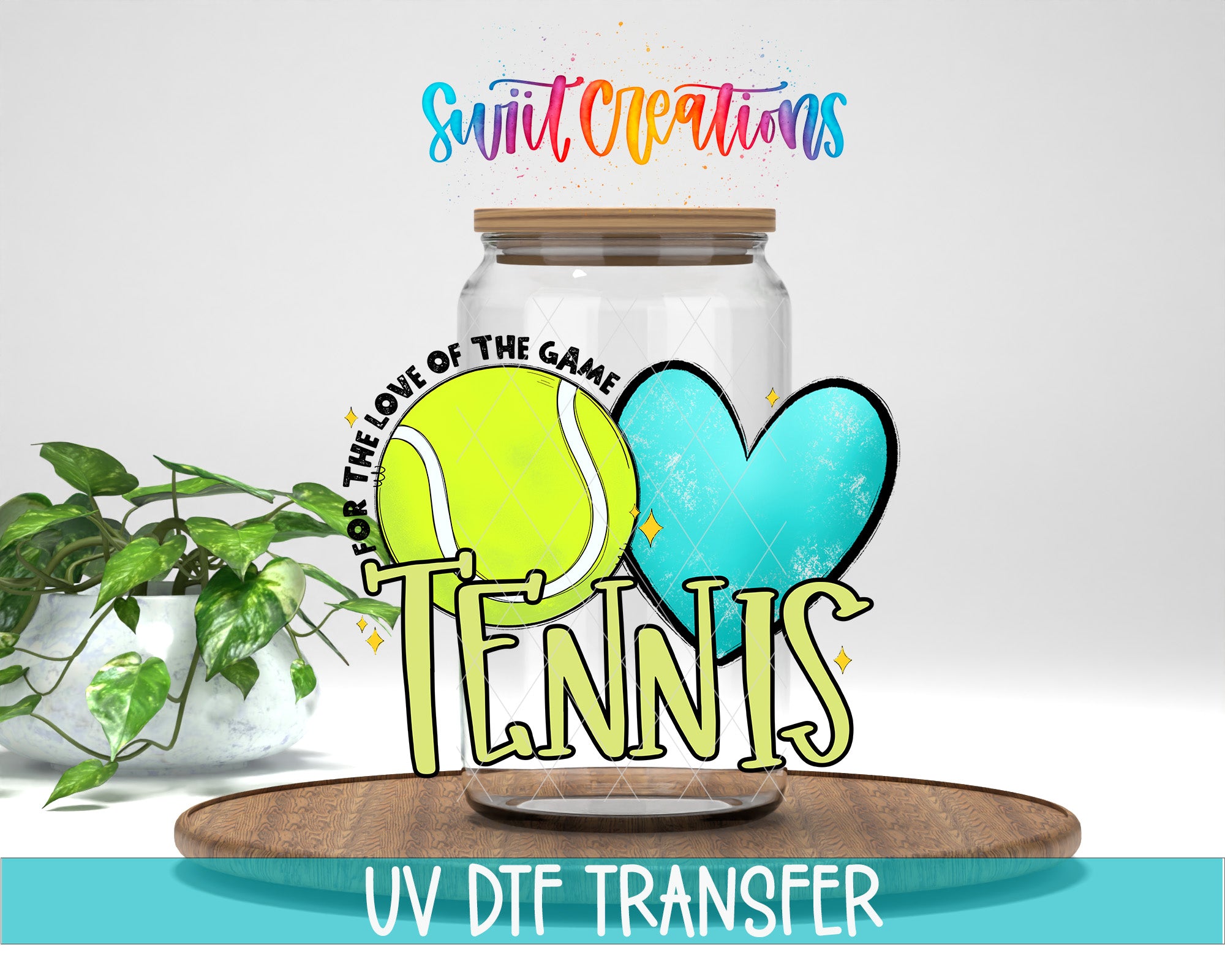 A glass jar with a tennis ball and heart inside, along with the text "Tennis" and "Swift Creations" written on it. The jar is placed on a wooden surface, and there is a potted plant in the background.