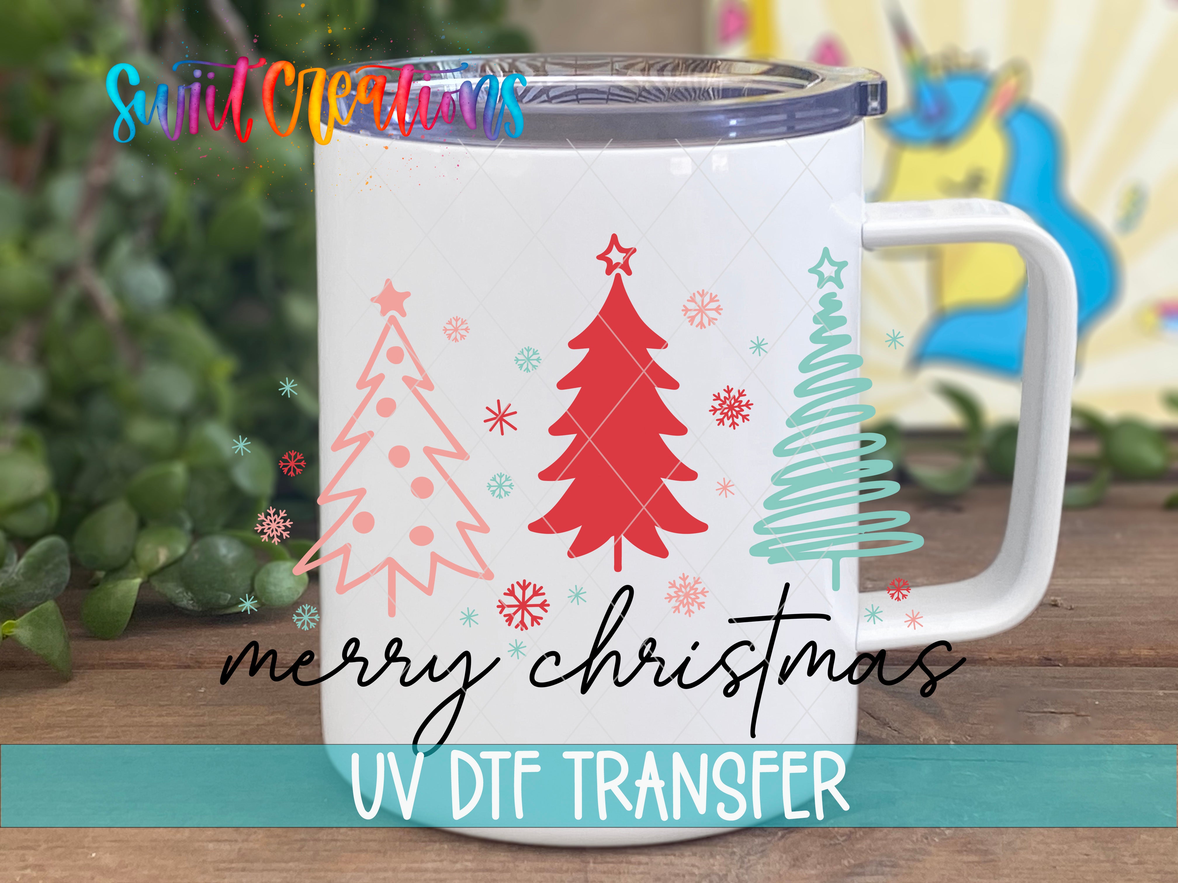 A white mug with a festive Christmas tree design and snowflakes on it, along with the text "Merry Christmas" and "UV DFT Transfer".