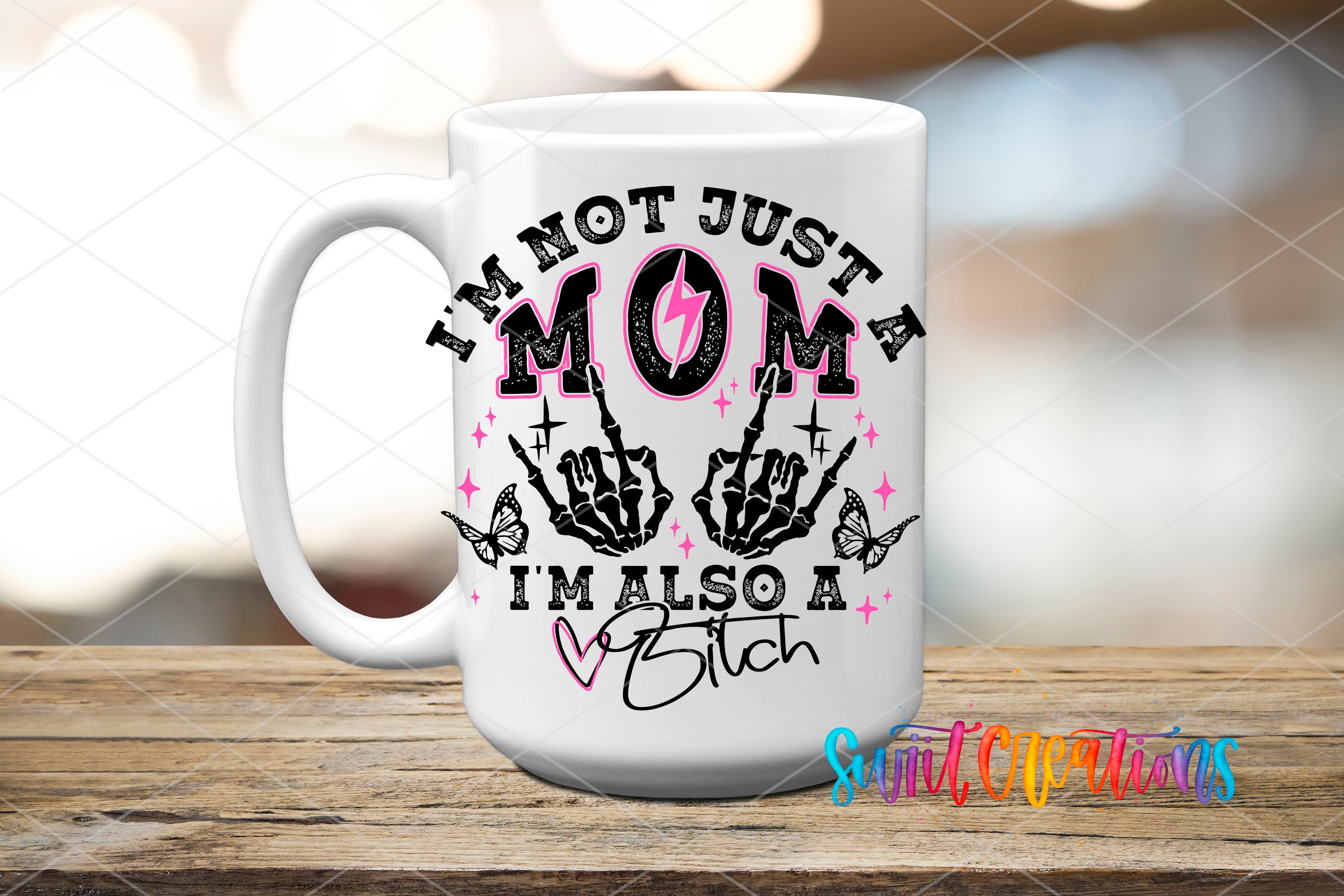 A white ceramic mug with a graphic design featuring a mother's hand with a lightning bolt, butterflies, and the text "I'M NOT JUST A MOM A MALSO A BITCH".