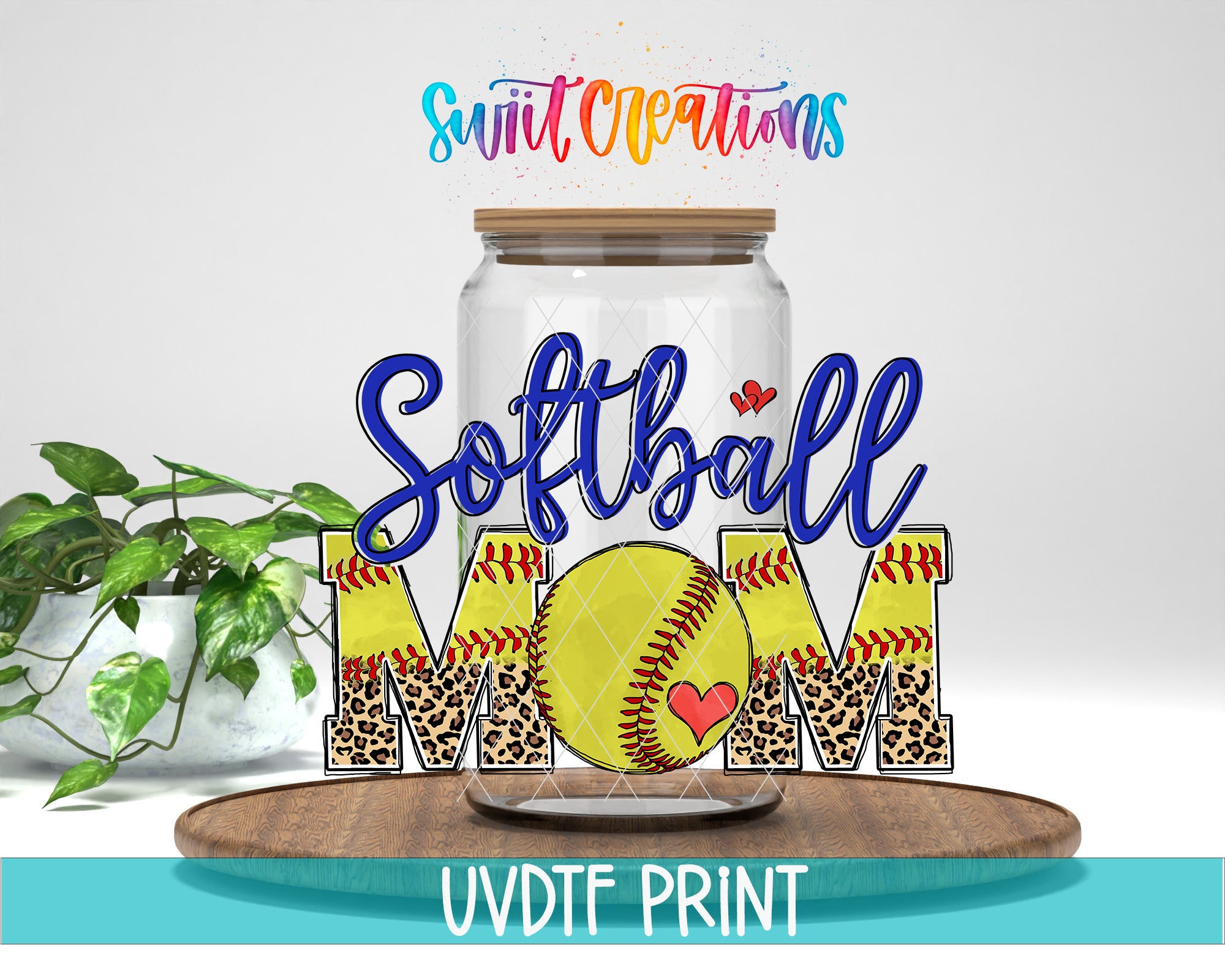 A glass jar with a leopard print design and a yellow softball inside, along with the text "Softball Mom" written on it. The jar is placed on a wooden surface, and there is a plant in the background.