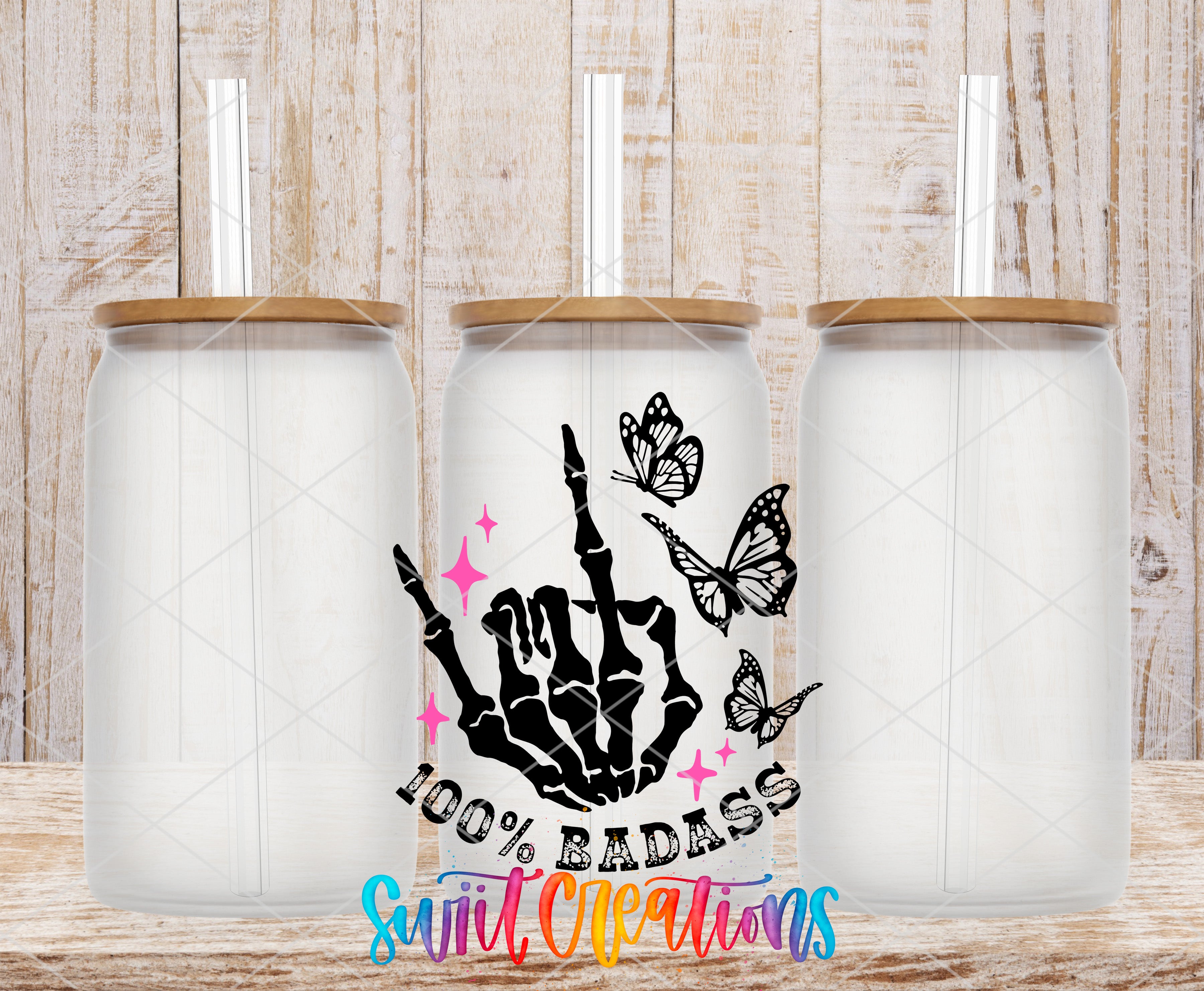 three glass jars with lids, each containing a straw. The jars are arranged in a row, and there is a hand-drawn design on the front of one of the jars, which includes a skeleton hand and butterflies. The design also includes the text "100% BADASS" and "Swift Cleaners".