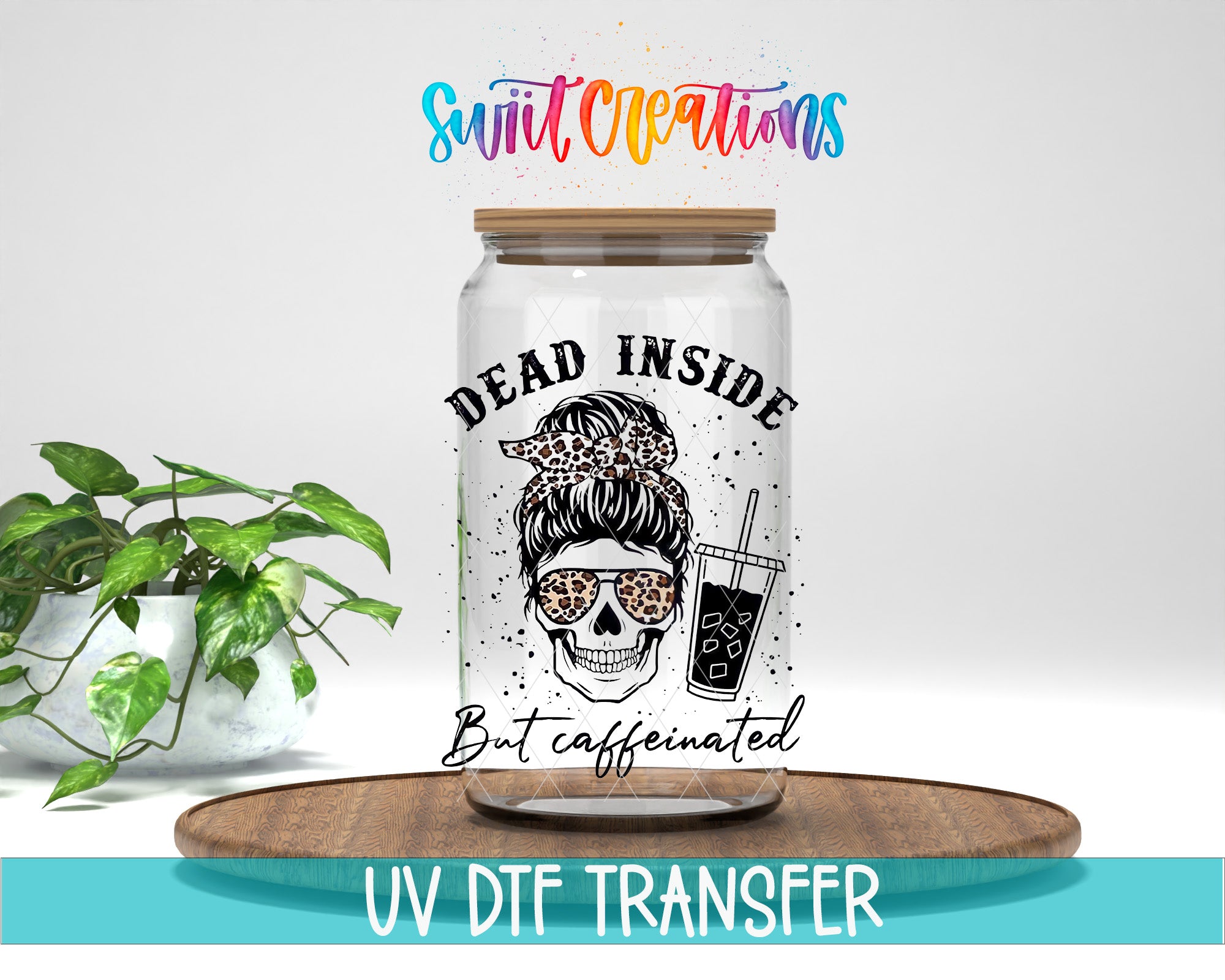 A glass jar with a skull design and the text "Dead inside but caffeinated" printed on it, placed on a wooden surface.