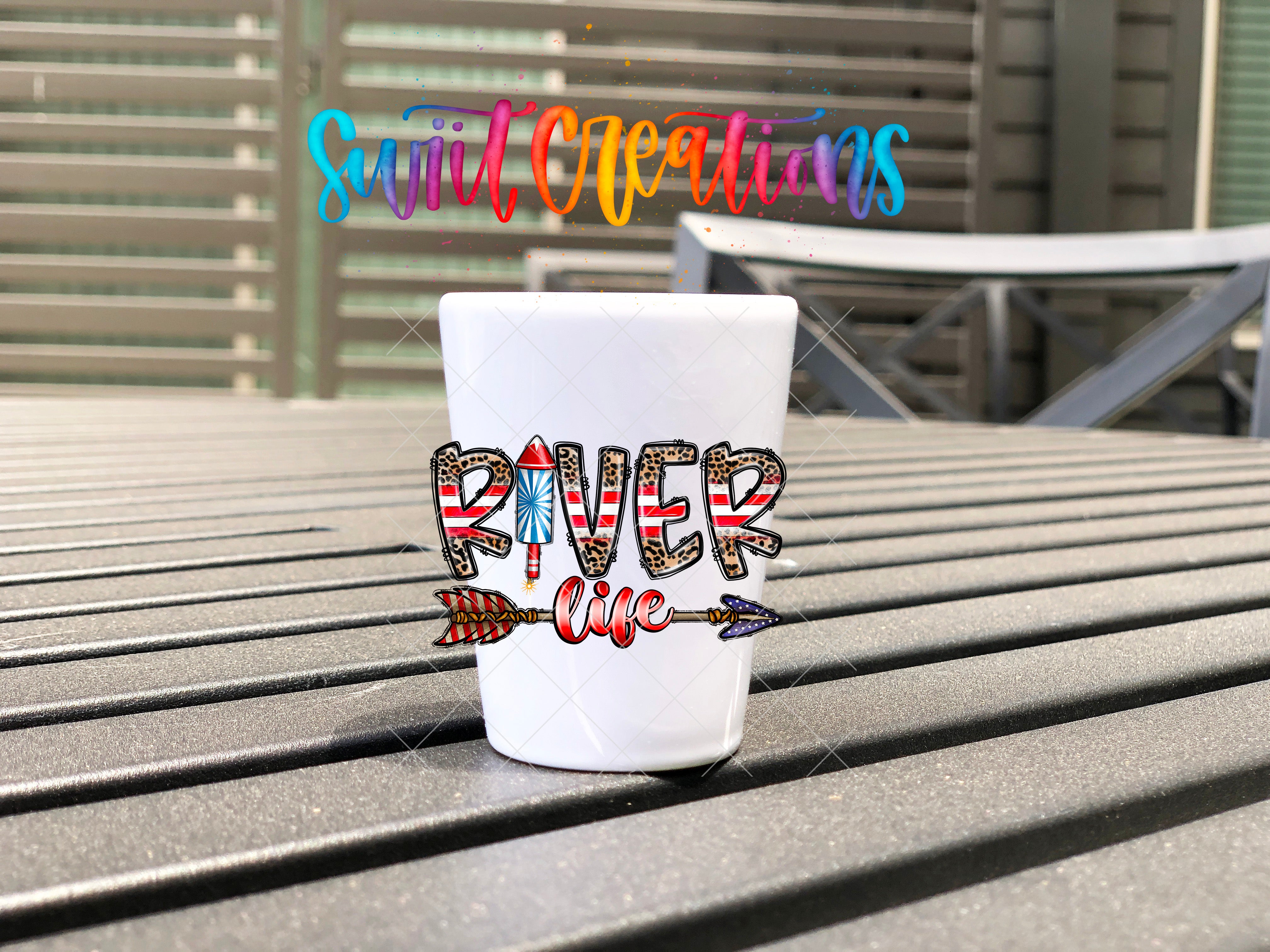 A white cup with the word "RIVER" printed on it, sitting on a wooden surface.