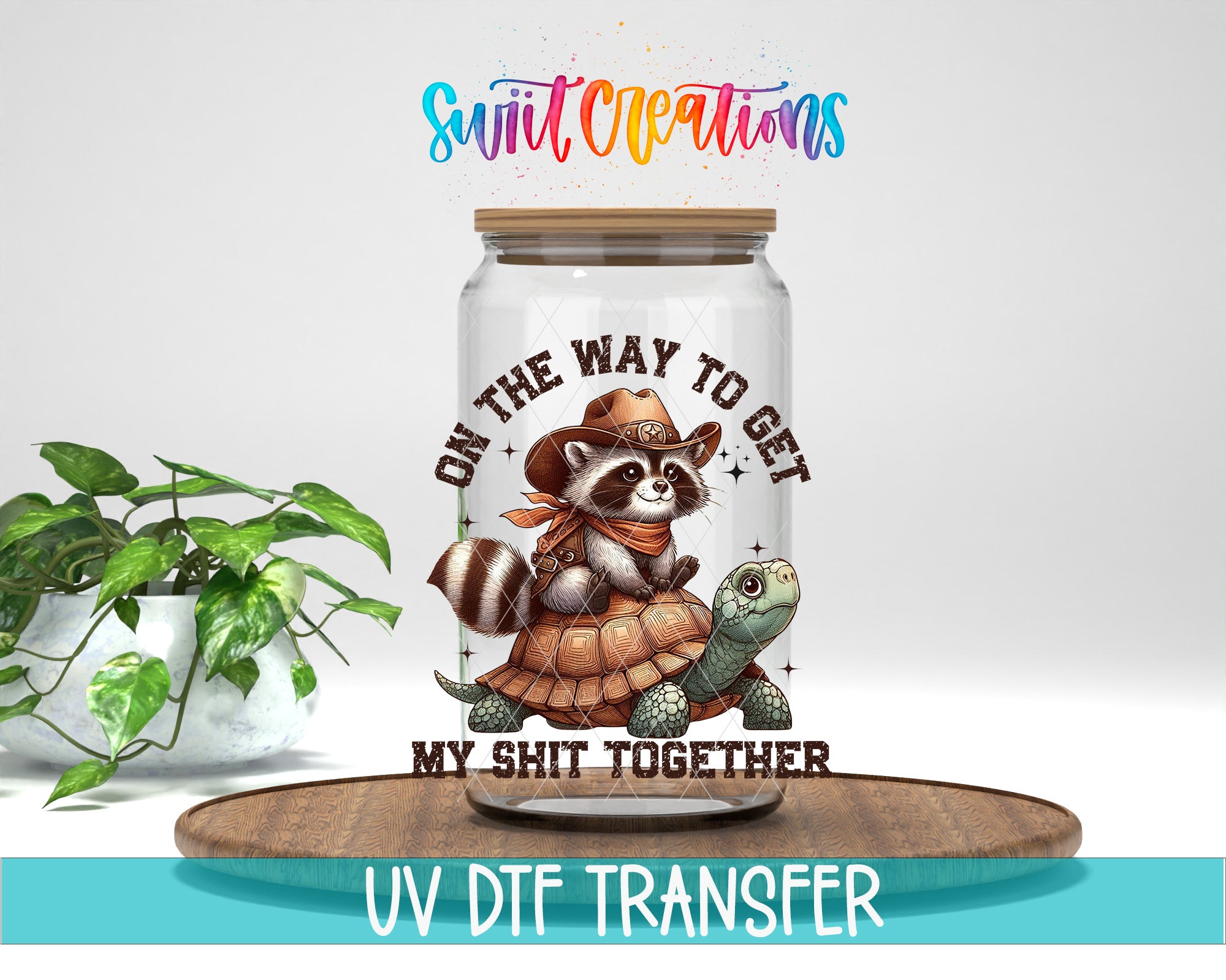 a jar with a raccoon wearing a cowboy hat and holding a turtle, along with the text "ON THE WAY TO GET MY SHIT TOGETHER" and "UV DFT TRANSFER".