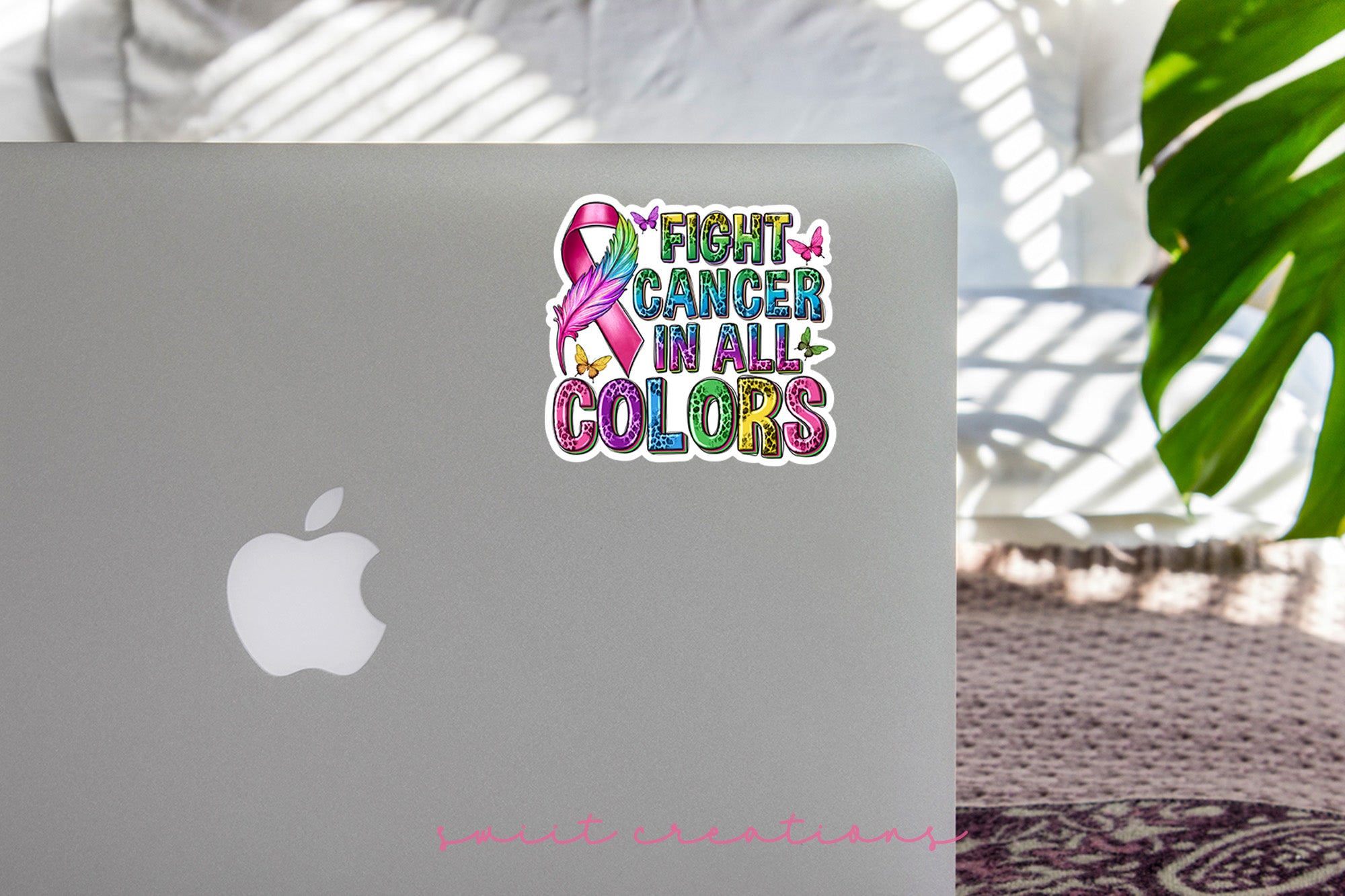 a laptop on a table with a sticker that says fight cancer in all colors