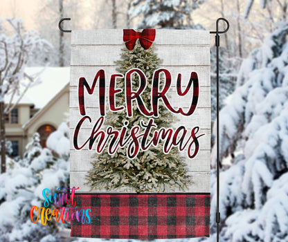 A white wooden Christmas tree with a red bow, surrounded by snow-covered trees, with the text "MERRY CHRISTMAS" displayed on the tree.
