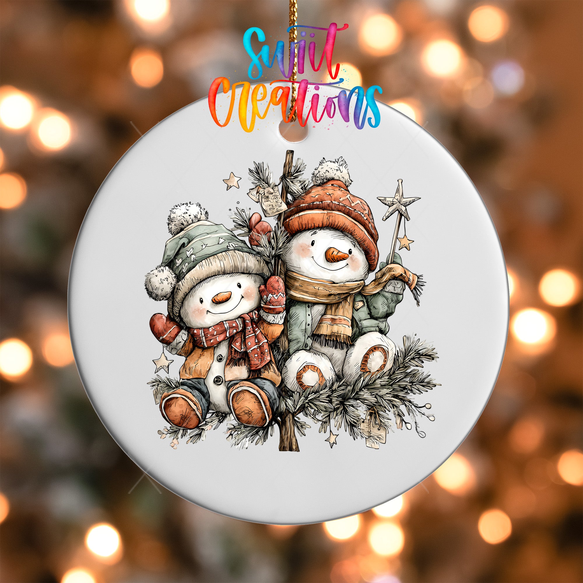 A white ornament featuring two snowmen, one wearing a green hat and the other wearing a red hat, sitting on a branch with pine cones and stars.