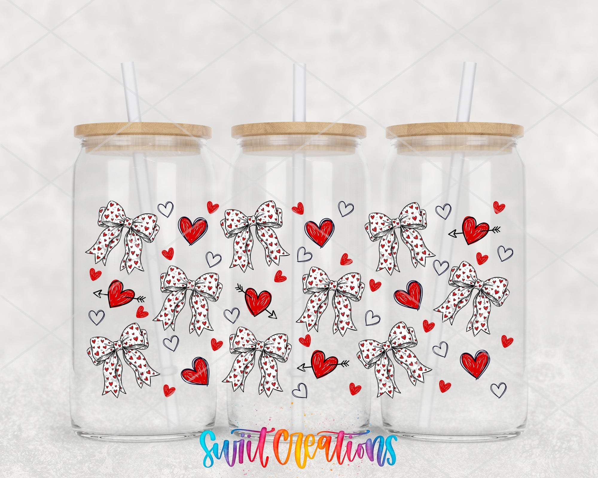 Three glass tumblers with wooden lids, each adorned with a bow and heart design.