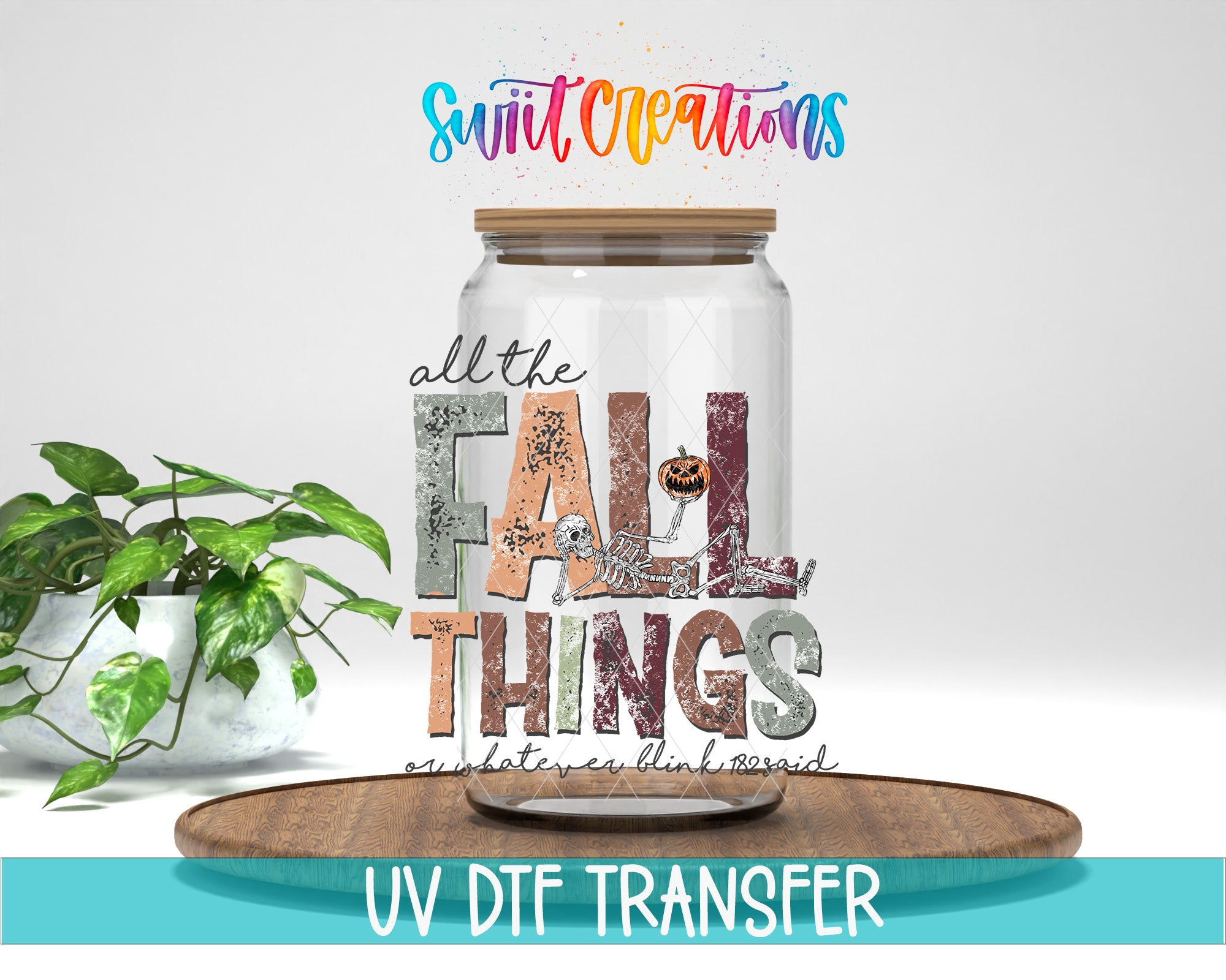 a glass jar with a label that says "all the FALL THINGS" and a pumpkin graphic, placed on a wooden surface. There is also a potted plant in the background.