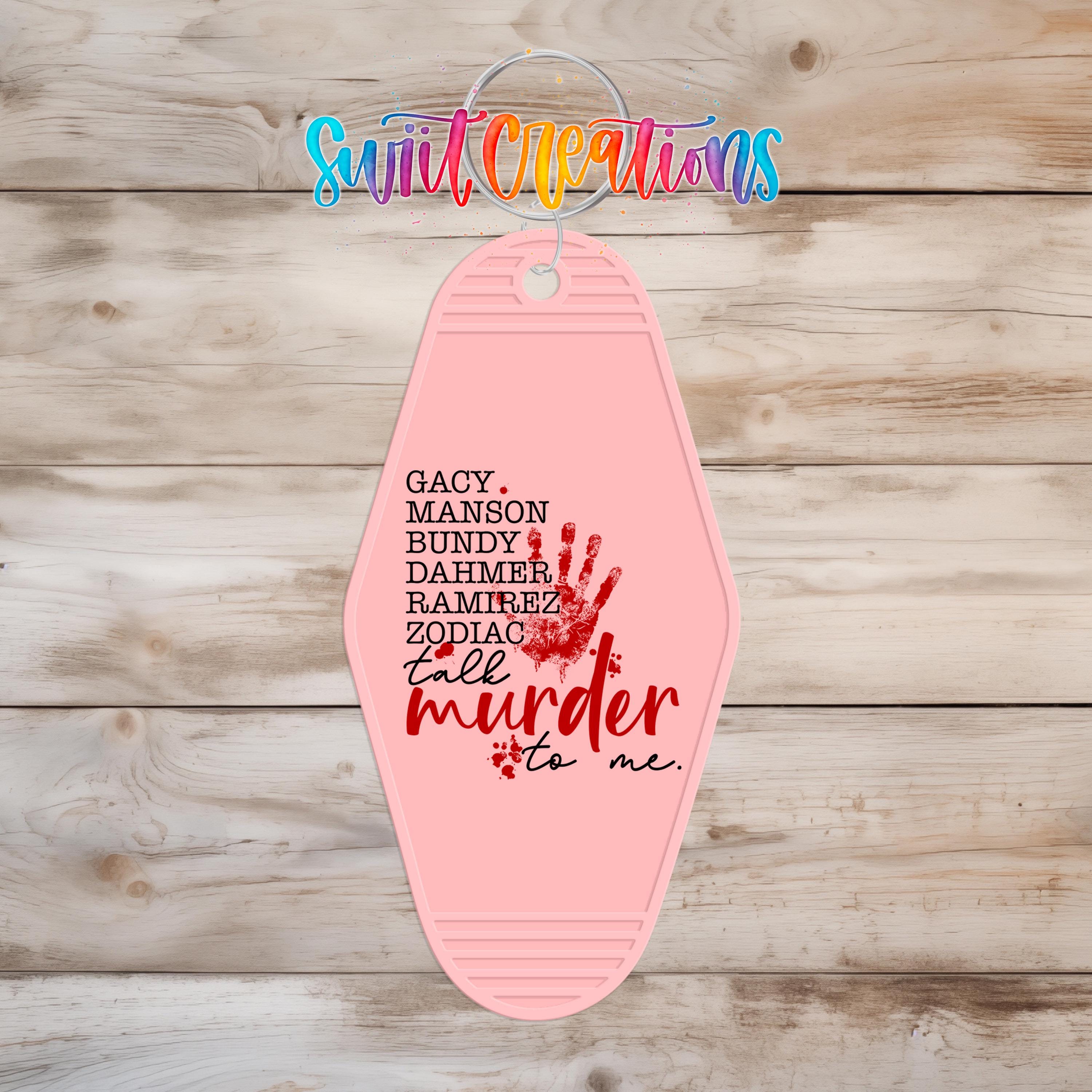A pink keychain with the text "GACY, MASSON, BUNDY, DAMMER, RAMIREZ, ZODIAC, TALK, MURDER, TO ME" printed on it.