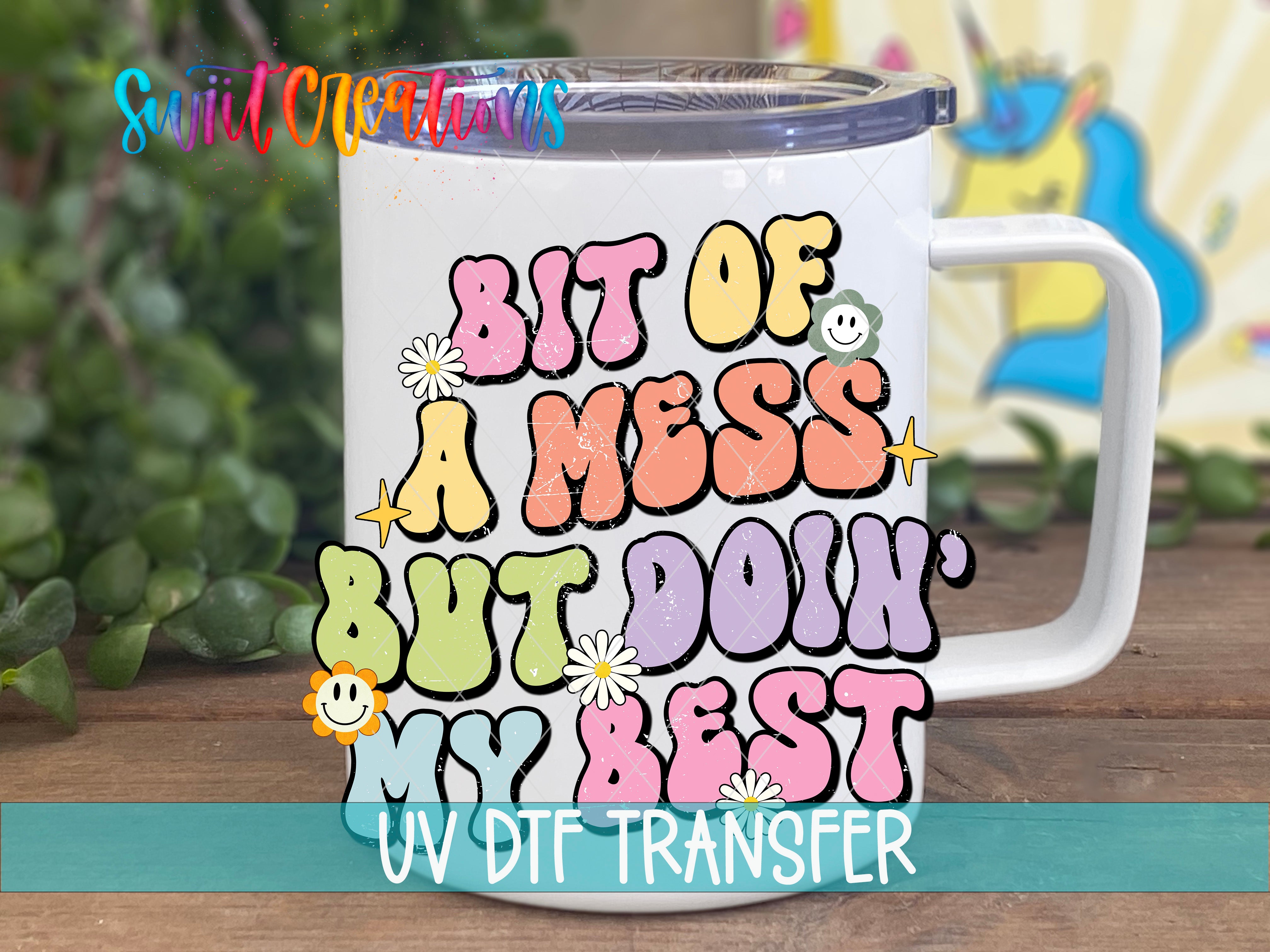 A white mug with colorful text and illustrations on it, placed on a wooden surface.