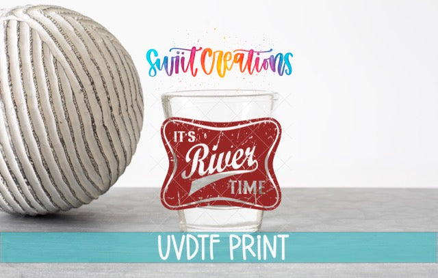 a glass with a red label that says "It's River Time" and a white ball with a striped pattern. The text "Swift Creations" is written above the glass, and "UVDF PRINT" is written below the glass.