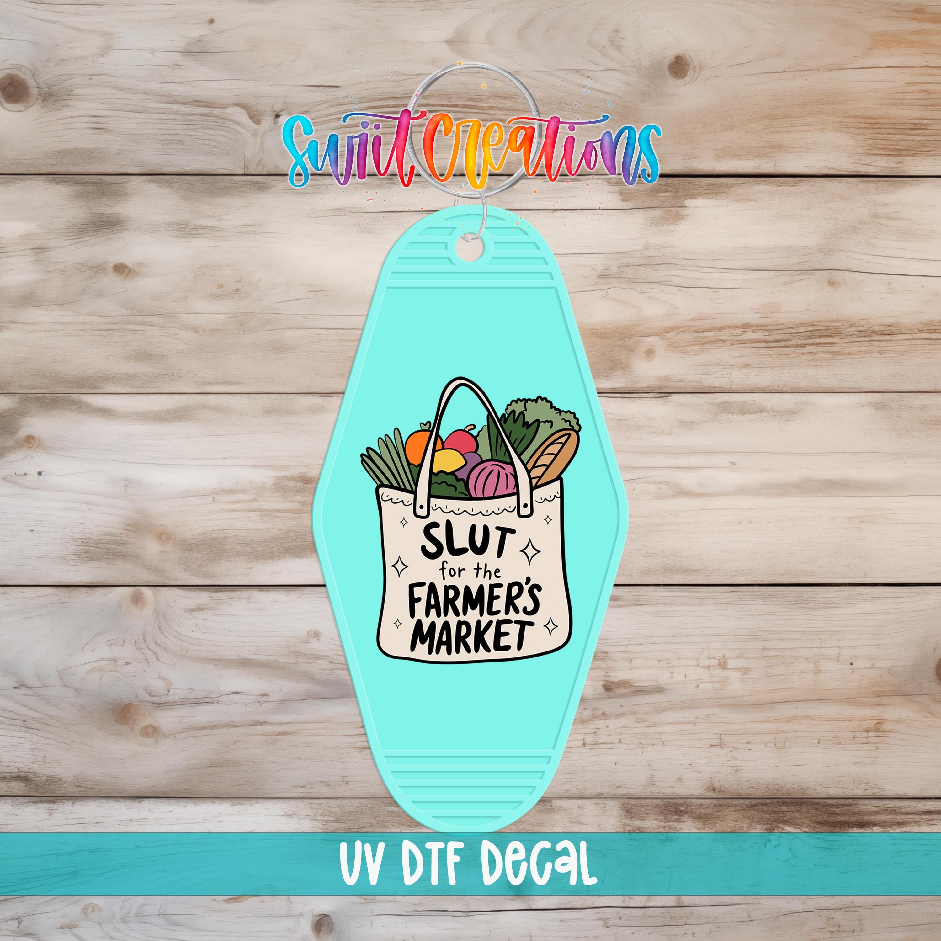 A turquoise keychain with a bag of vegetables and the text "SLUT for the FARMERS MARKET" printed on it, along with the text "UV Dtf Decal" at the bottom.