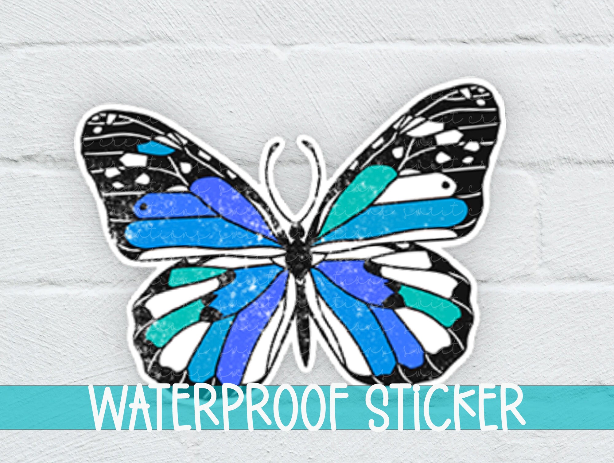 a blue and black butterfly sticker on a white brick wall