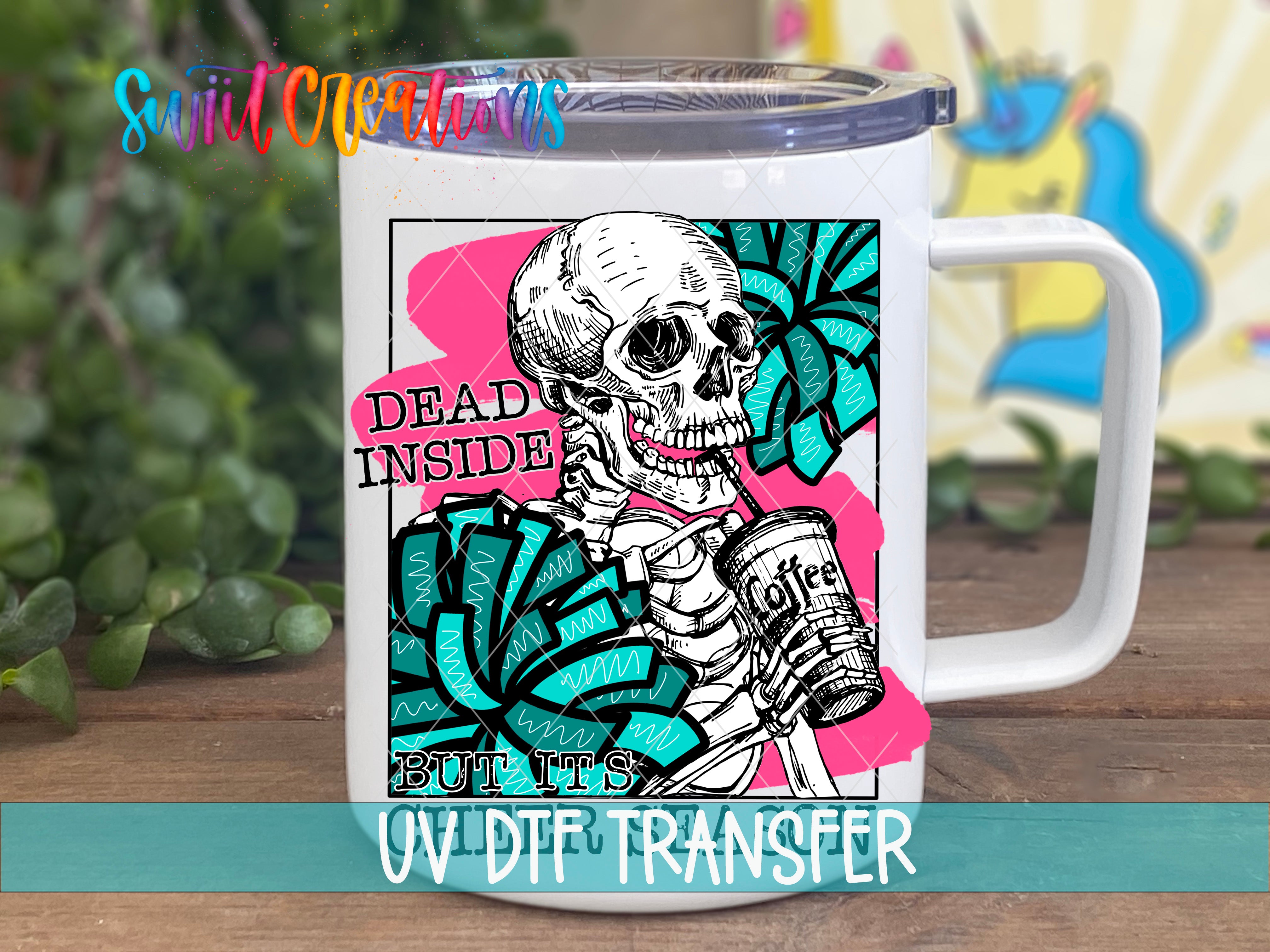 A white mug with a colorful graphic design featuring a skeleton holding a coffee cup, accompanied by the text "Dead inside but it's not".