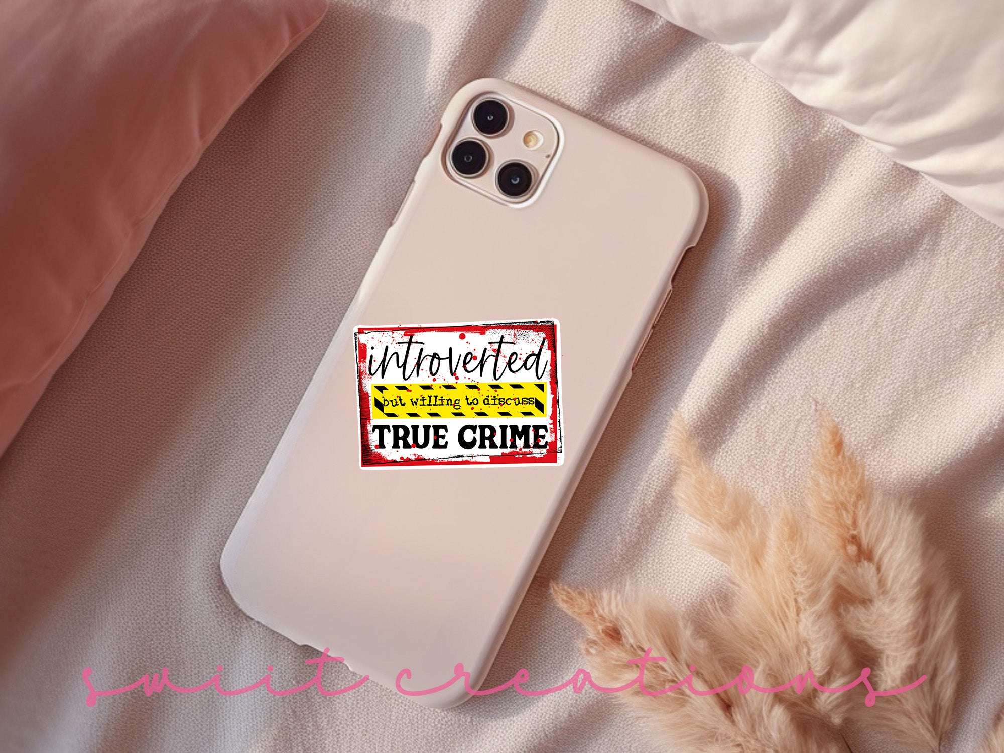 a phone case with a sticker on it sitting on a bed