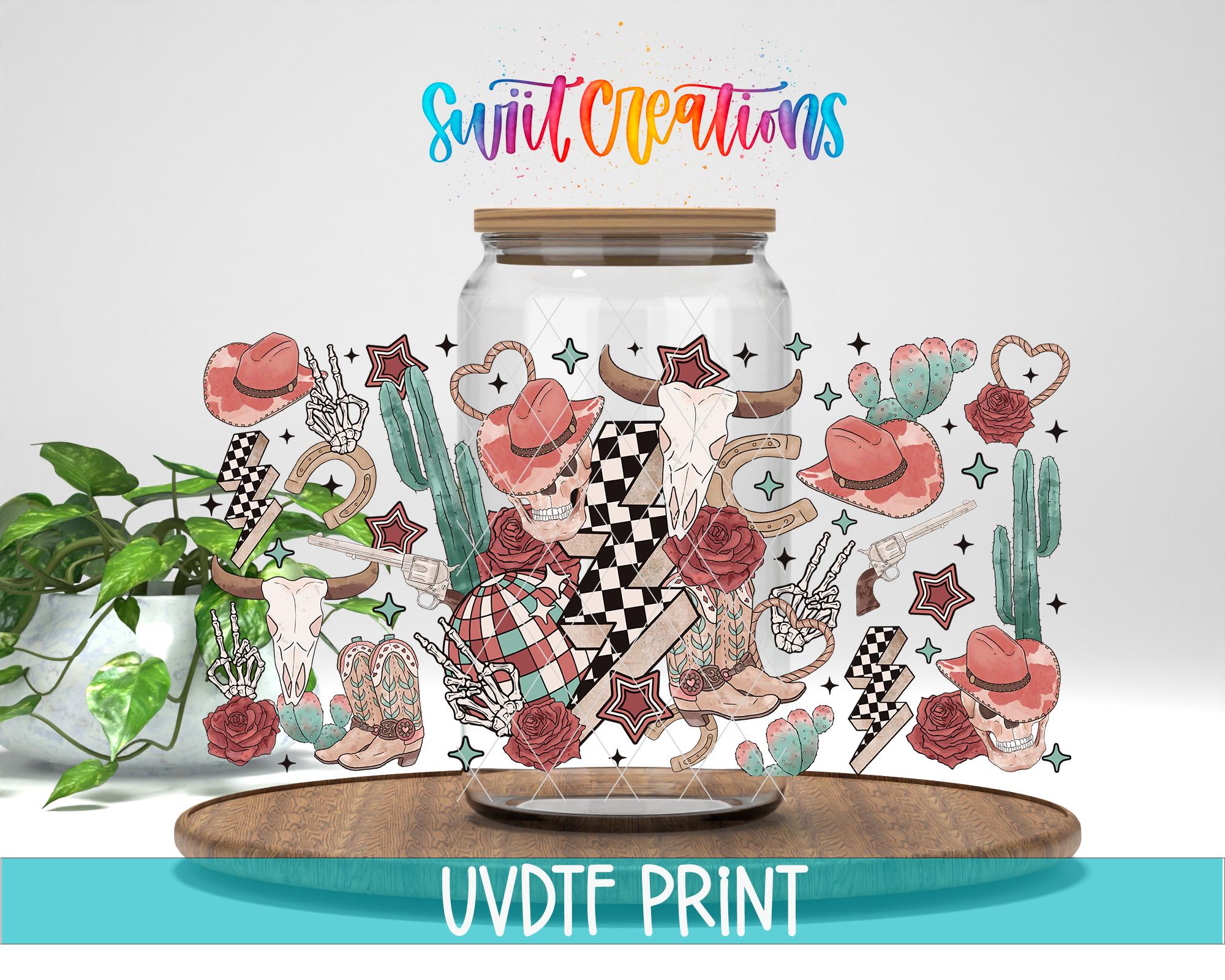 a glass jar with a colorful, whimsical design of various objects and symbols, including cacti, flowers, stars, and a cowboy hat. The jar is placed on a wooden surface, and there is a plant in the background. The text "Swift Creations" is written above the jar, and "UVDF PRINT" is written at the bottom of the image.