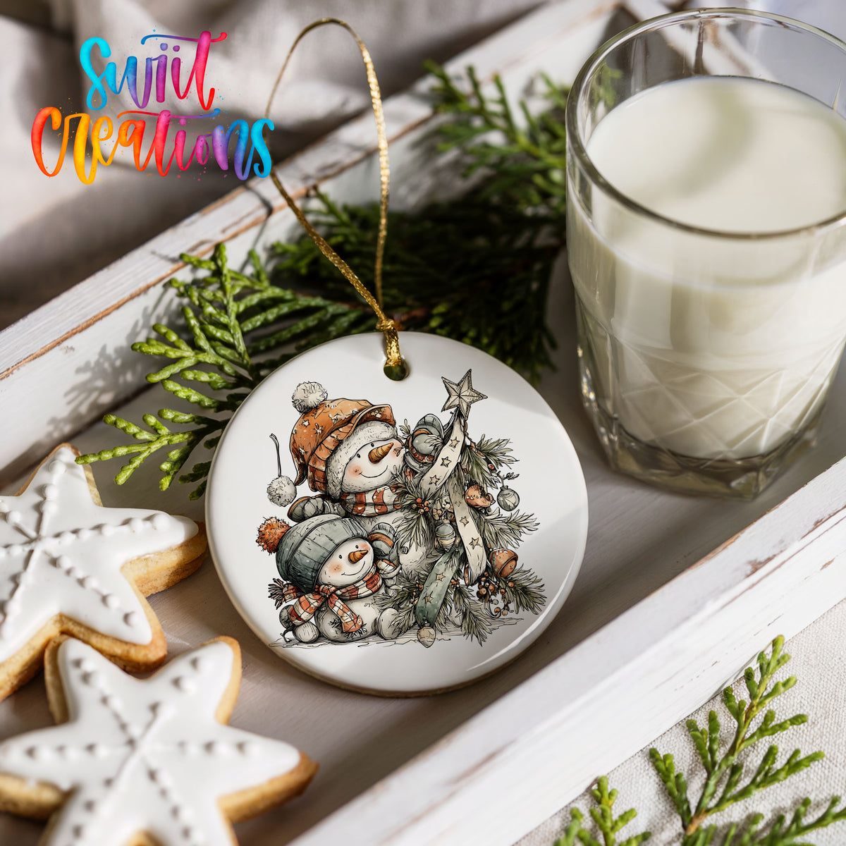 a festive scene with a snowman ornament, cookies, and a glass of milk on a white tray.