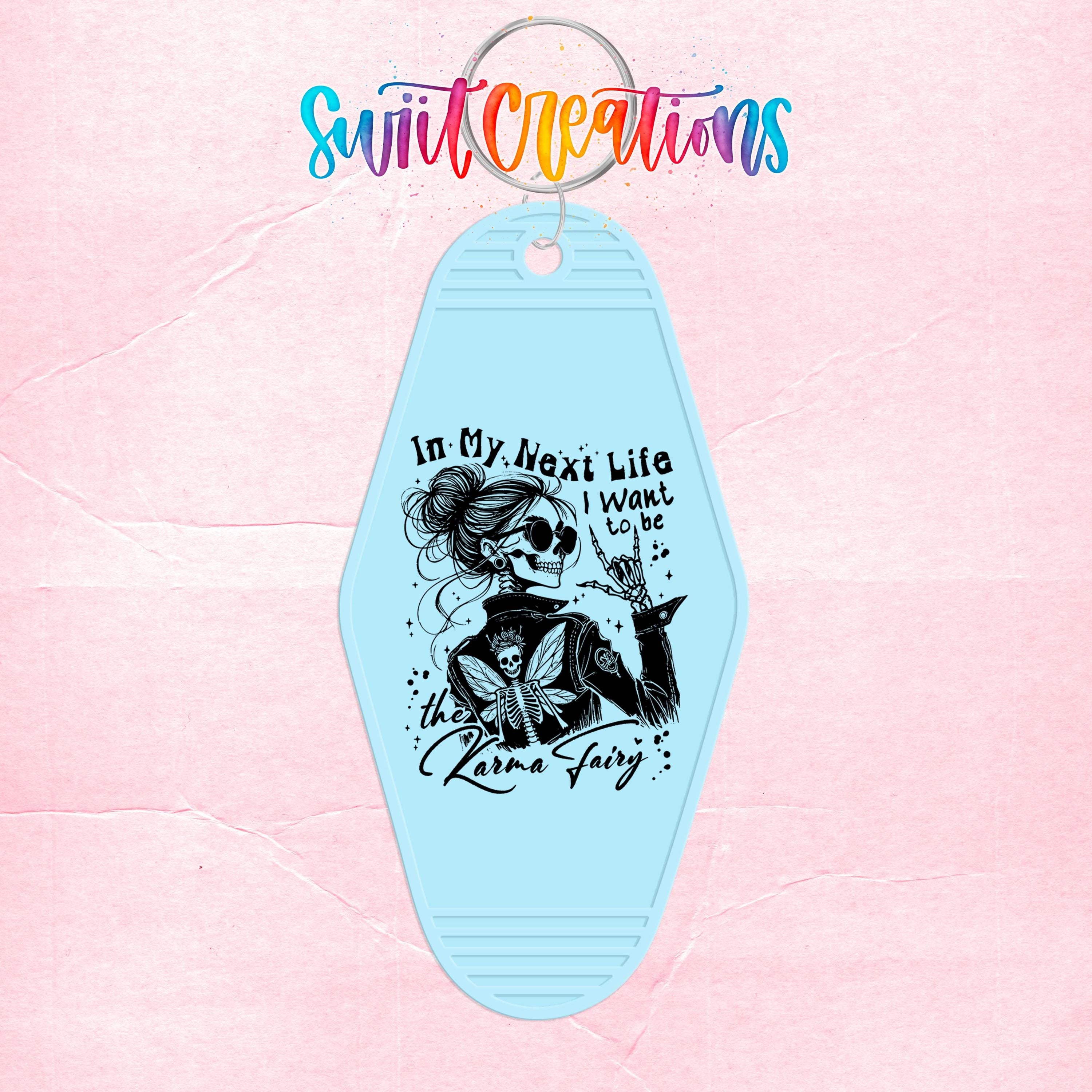 A keychain with a graphic design featuring a skull and a fairy, along with text that reads "In My Next Life I want to be the Karaoke Fairy".
