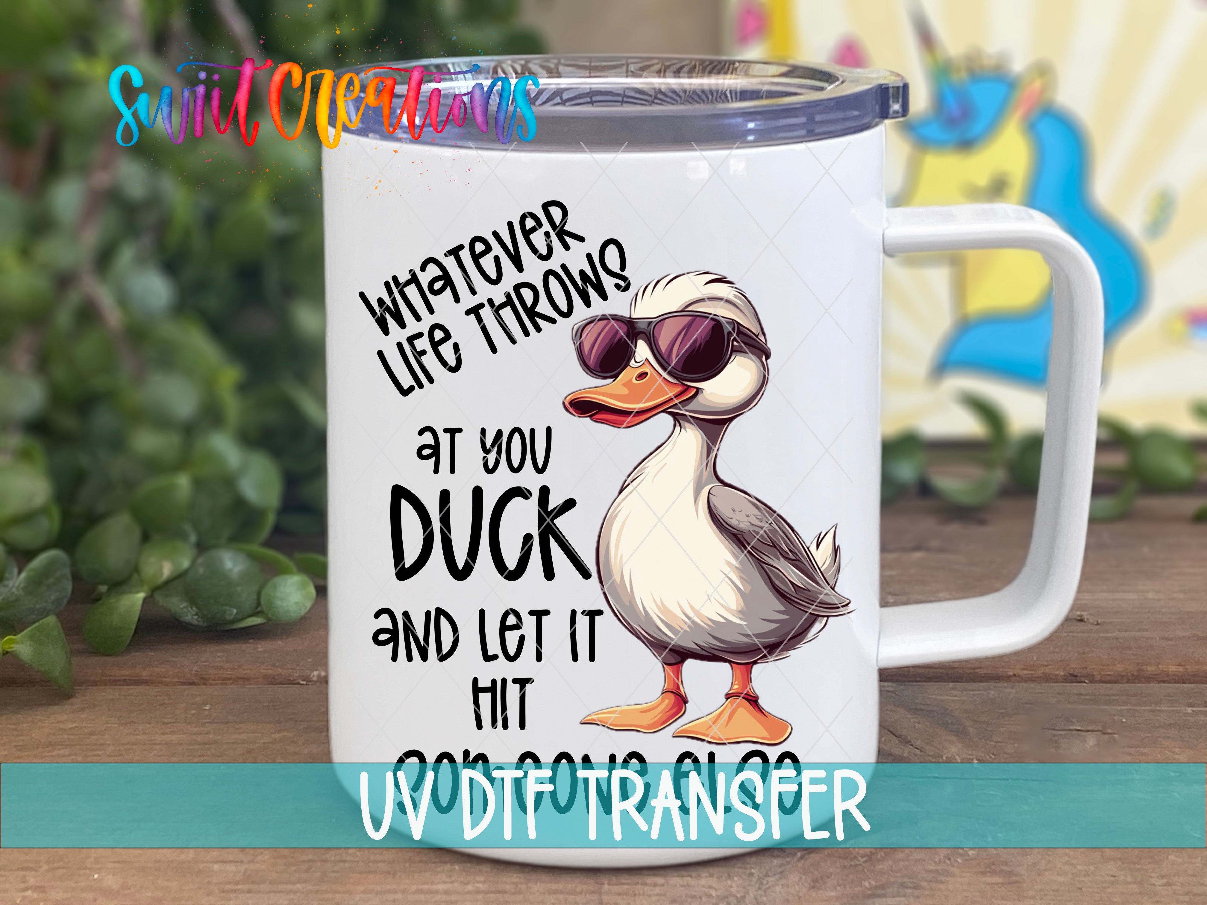 A white mug with a cartoon duck wearing sunglasses and the text "Whatever life throws at you, duck and let it hit your head" printed on it.