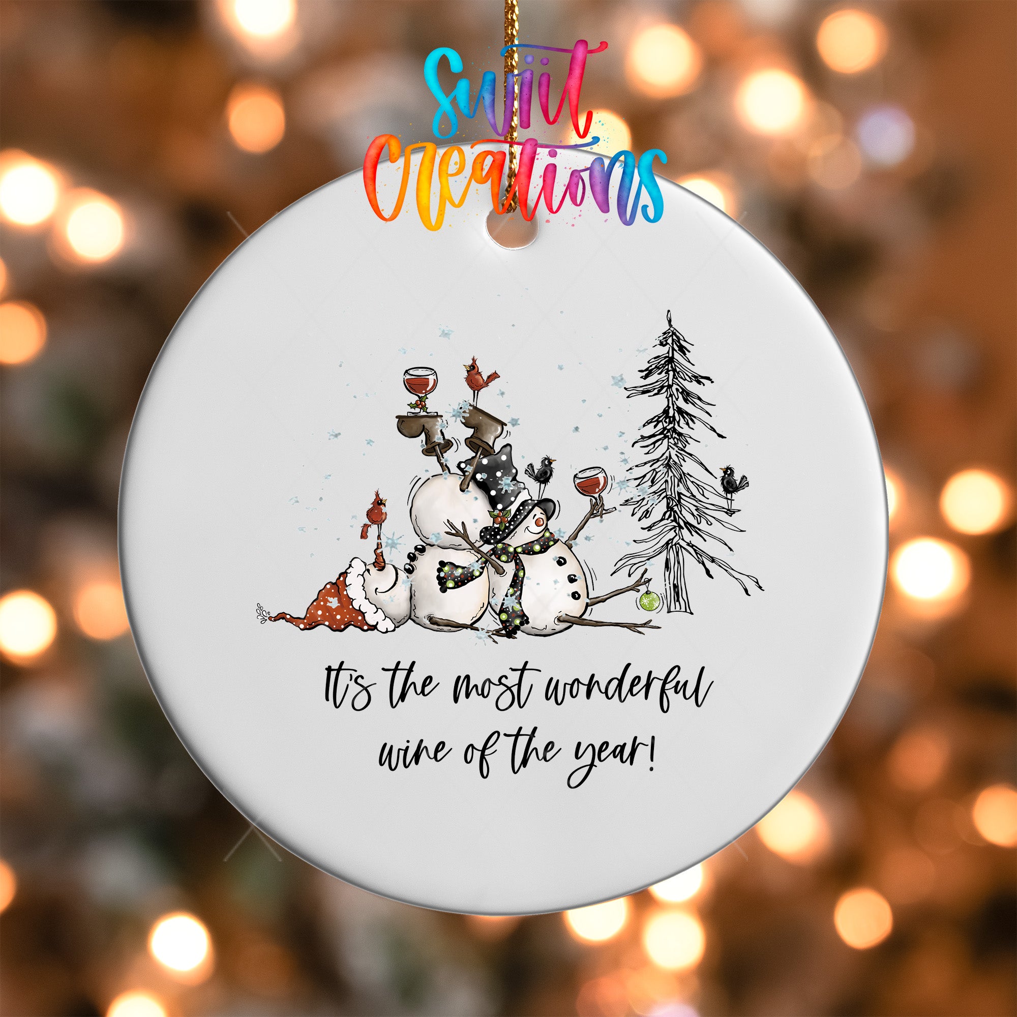 A white ornament with a snowman, a bird, and a tree, along with the text "It's the most wonderful wine of the year!"