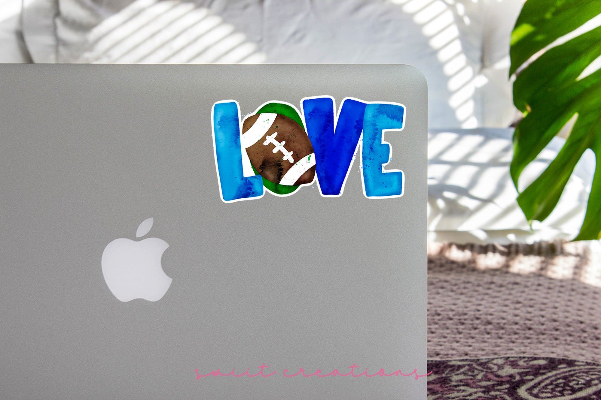 a laptop with a sticker of a football on it