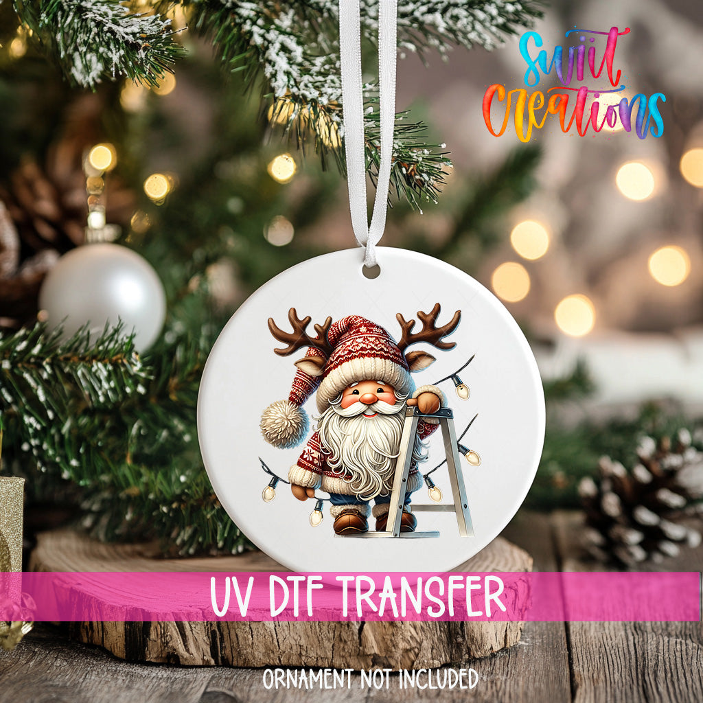 A white ornament with a Santa Claus image hanging on a Christmas tree.