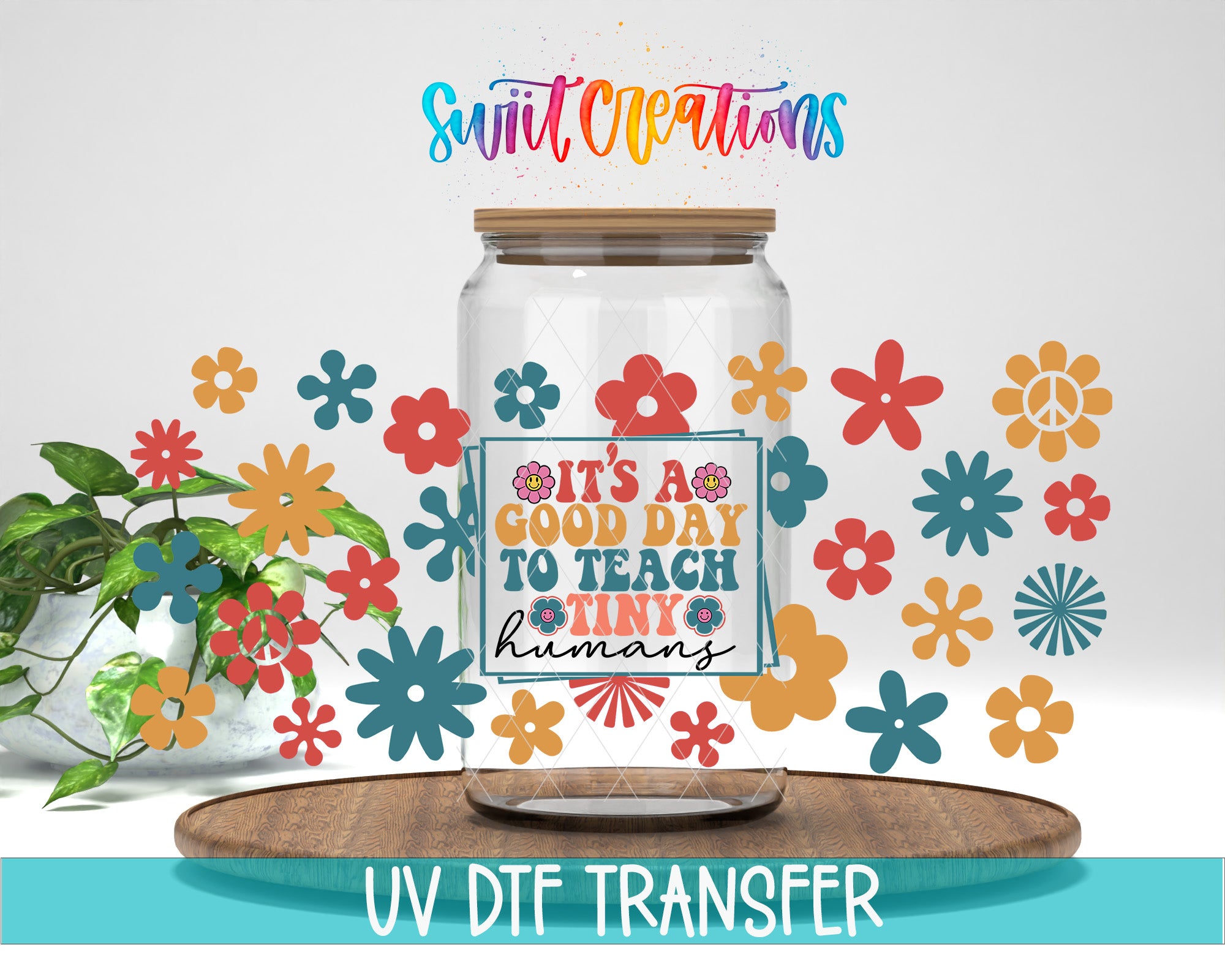 a clear glass jar with a label that says "IT'S A GOOD DAY TO TEACH TINY humans" surrounded by colorful flower decals. The jar is placed on a wooden board, and there is a potted plant in the background.